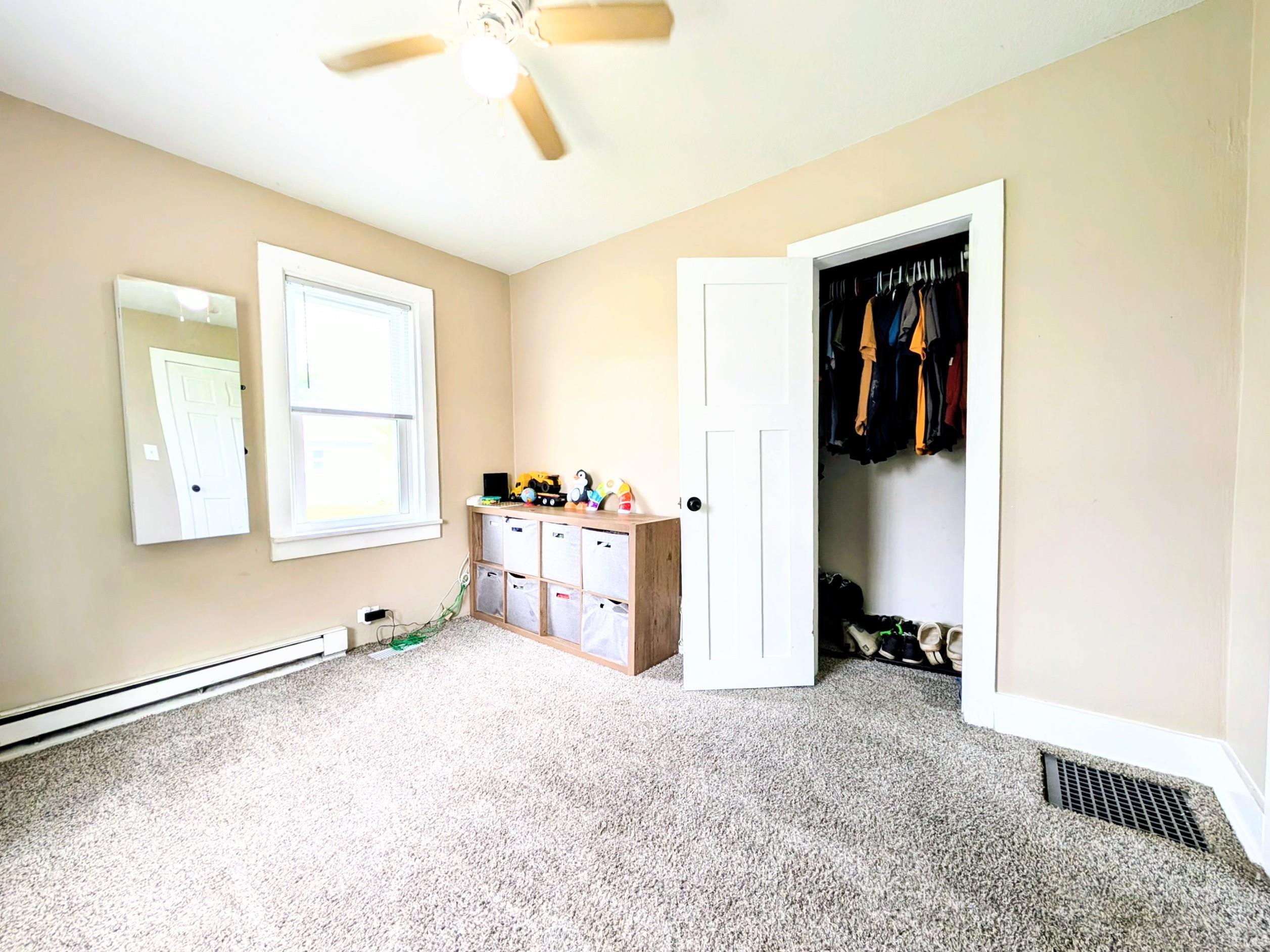 Carpeted room with a ceiling fan