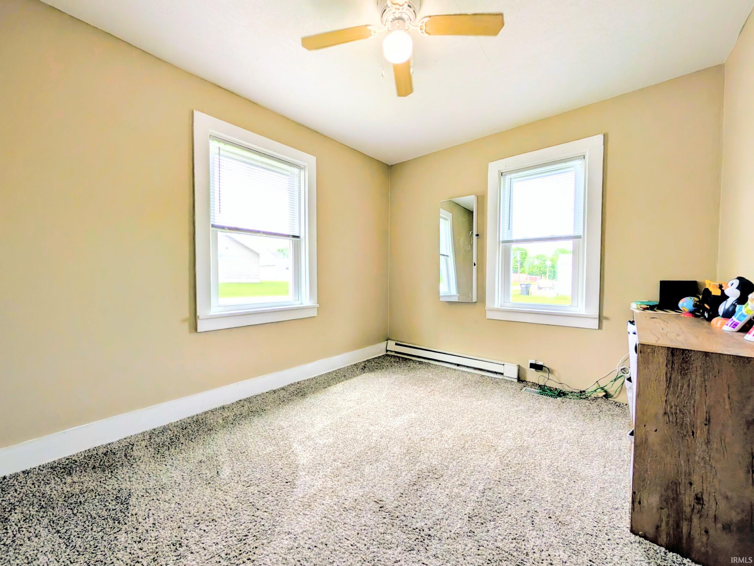 Neutral-toned room with light beige walls and new speckled carpet flooring