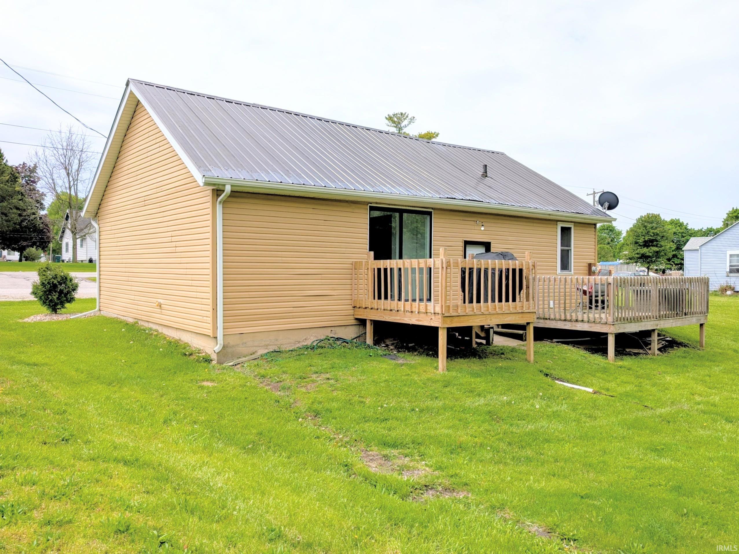 Rear exterior featuring a metal roof, horizontal siding, and two wooden deck spaces