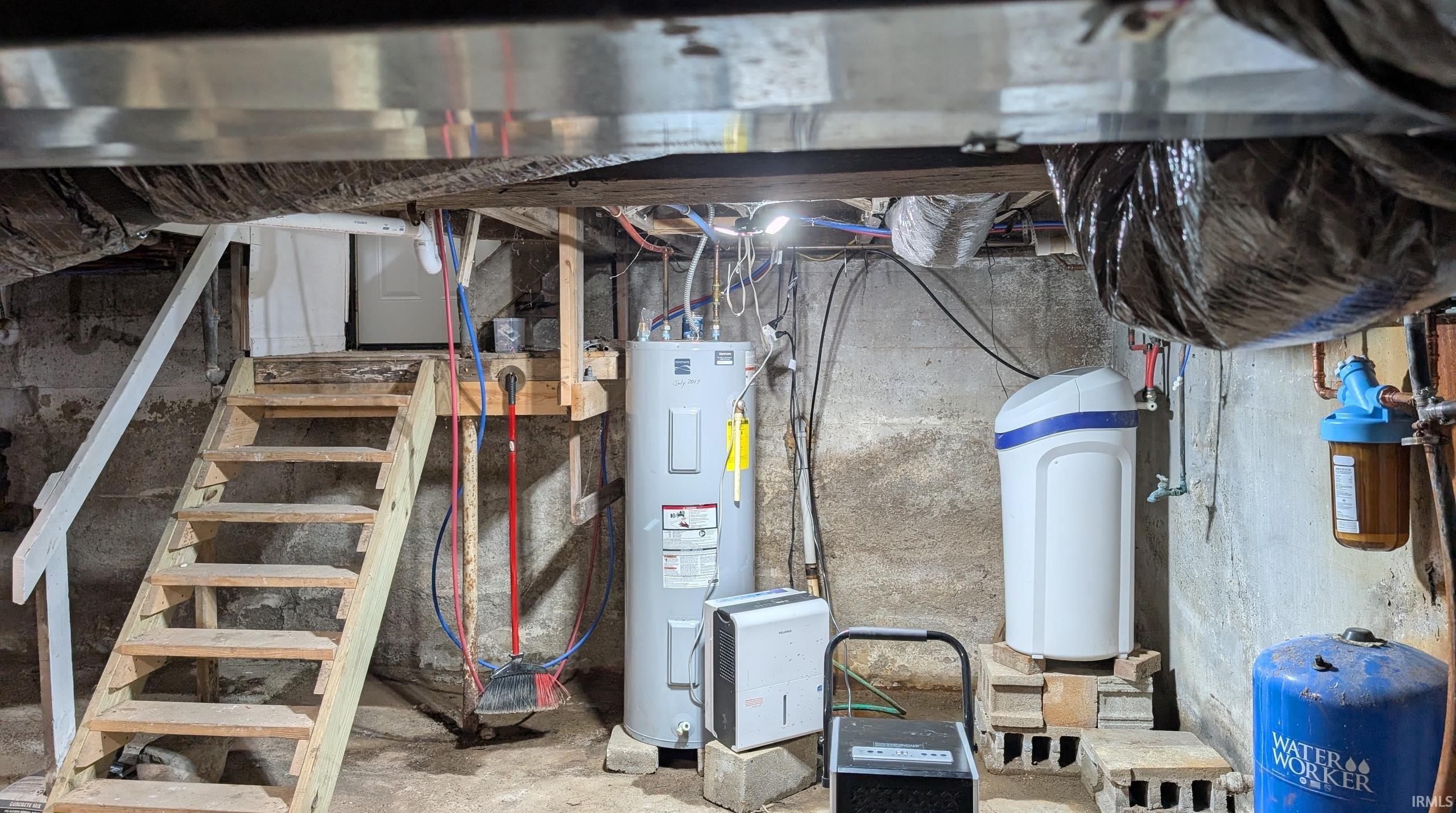Utility area featuring a water heater, water softener system, water filtration unit, and a pressurized water tank