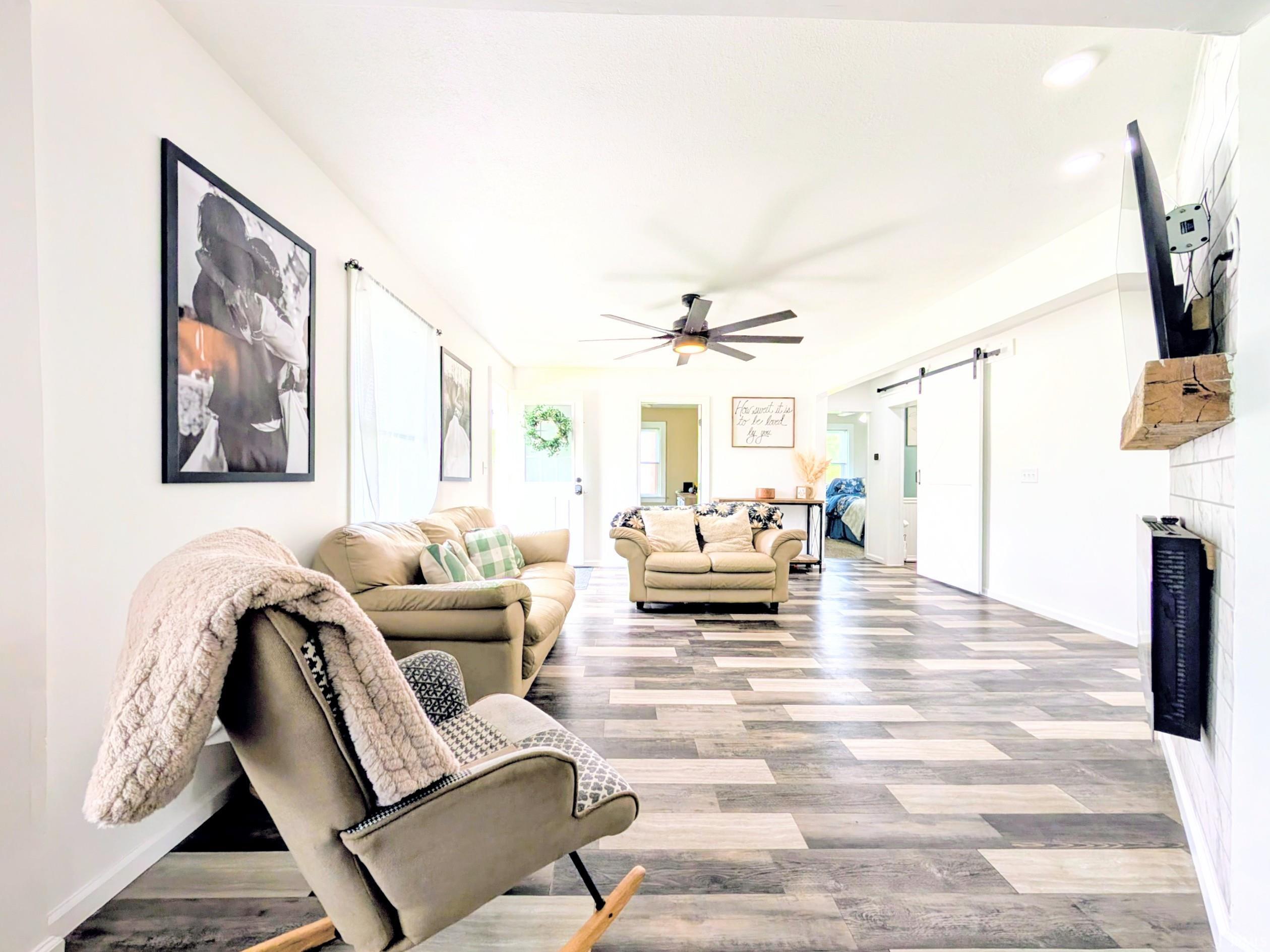Spacious living area featuring multi-tone wood-finish flooring and bright white walls