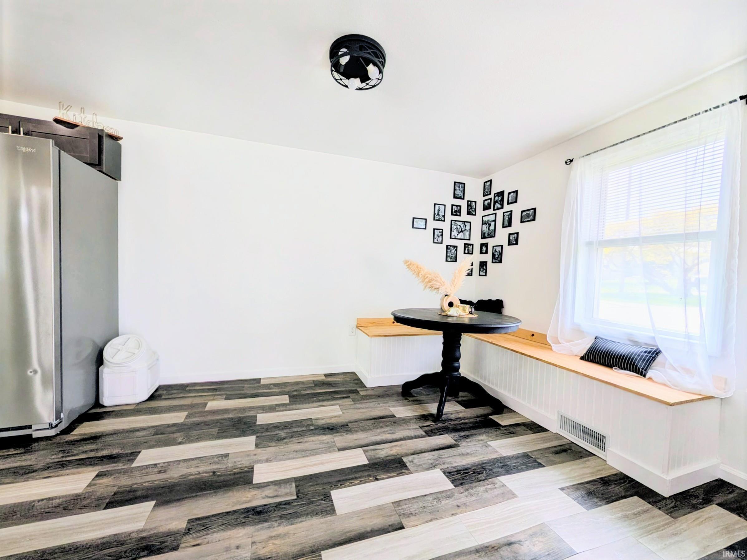 Spacious dining area featuring wood-finish flooring with varied tones