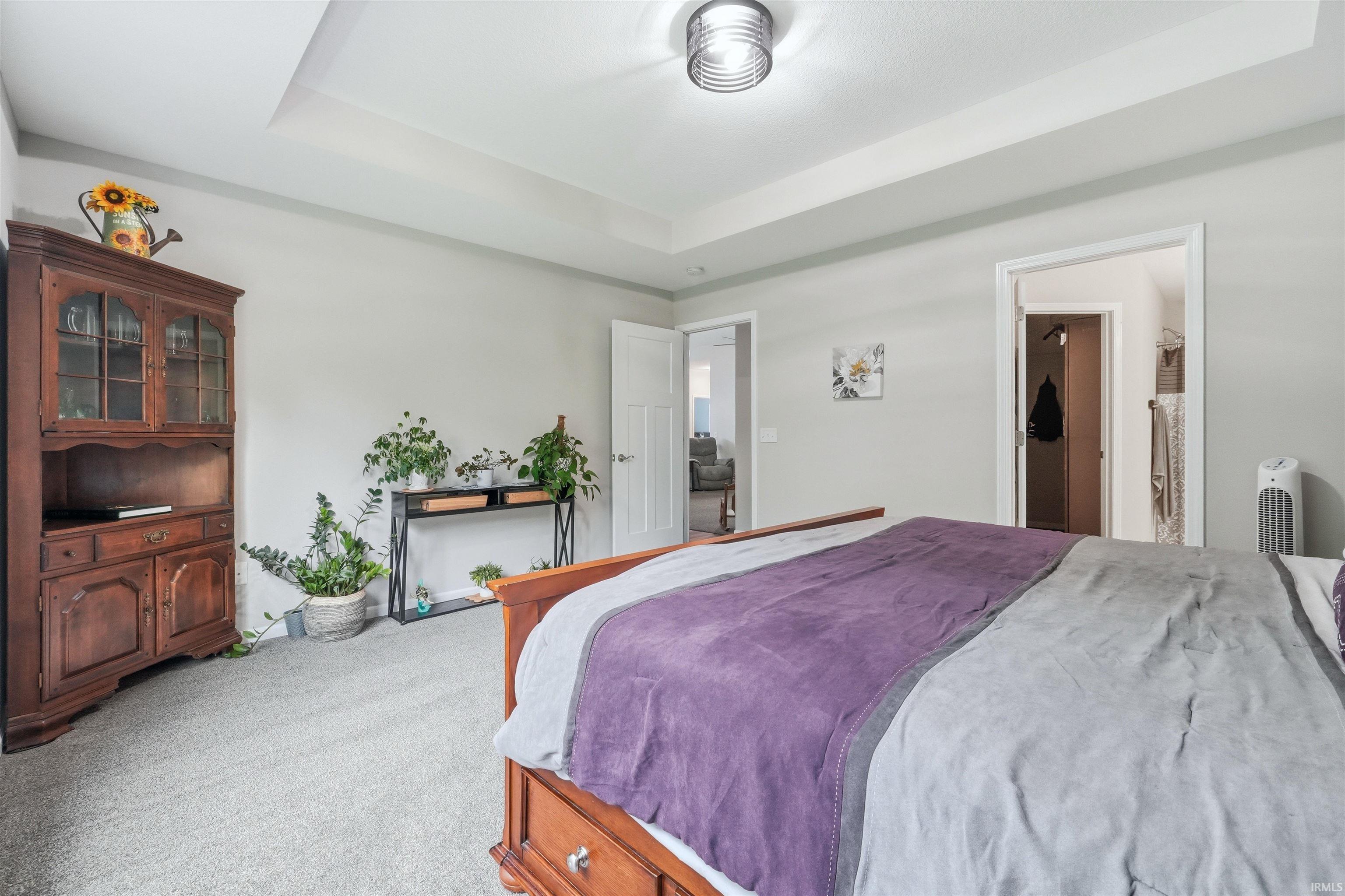 Bedroom featuring a tray ceiling, recessed lighting, and soft gray wall paint