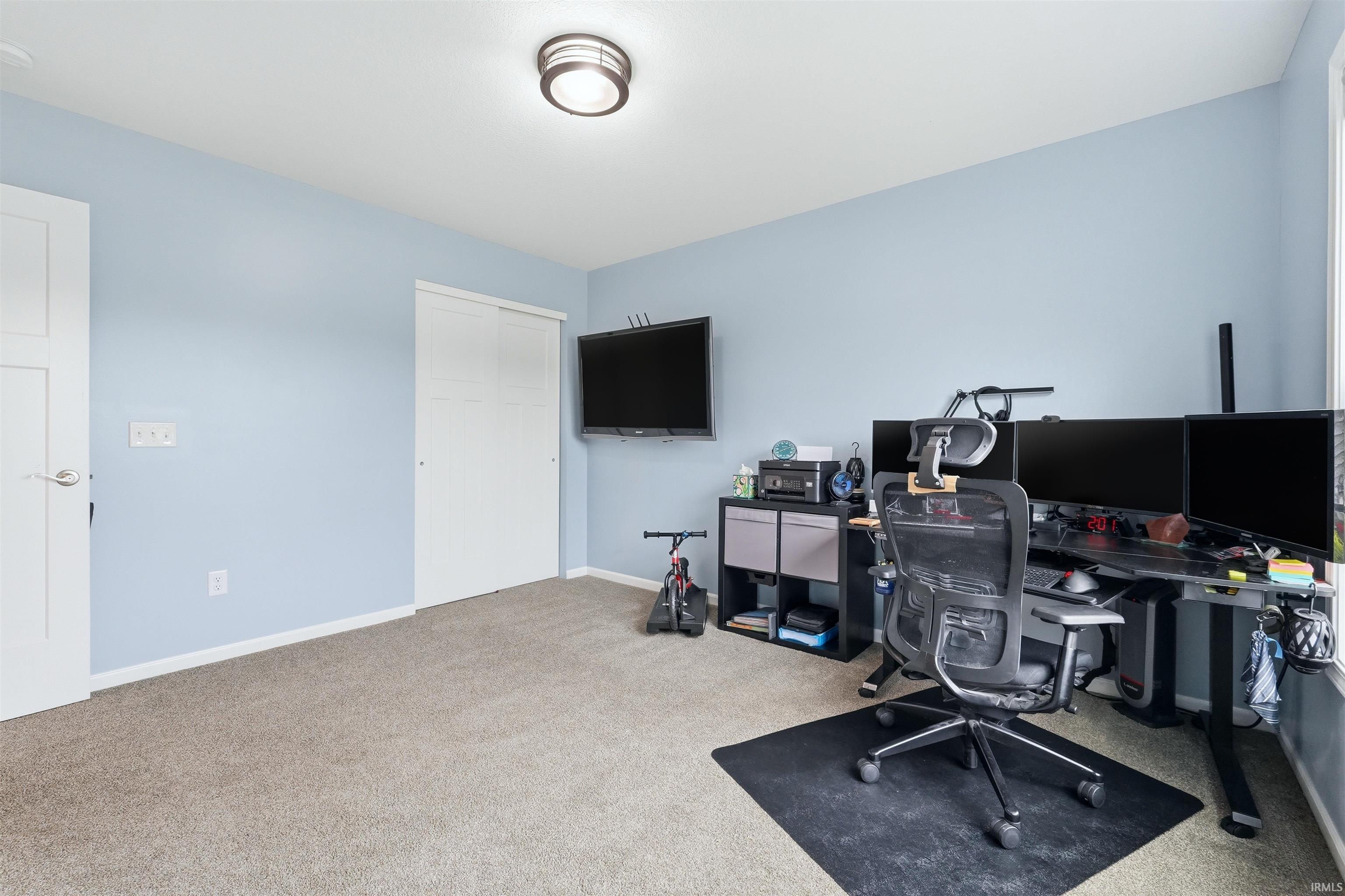 Carpeted interior room featuring light blue walls