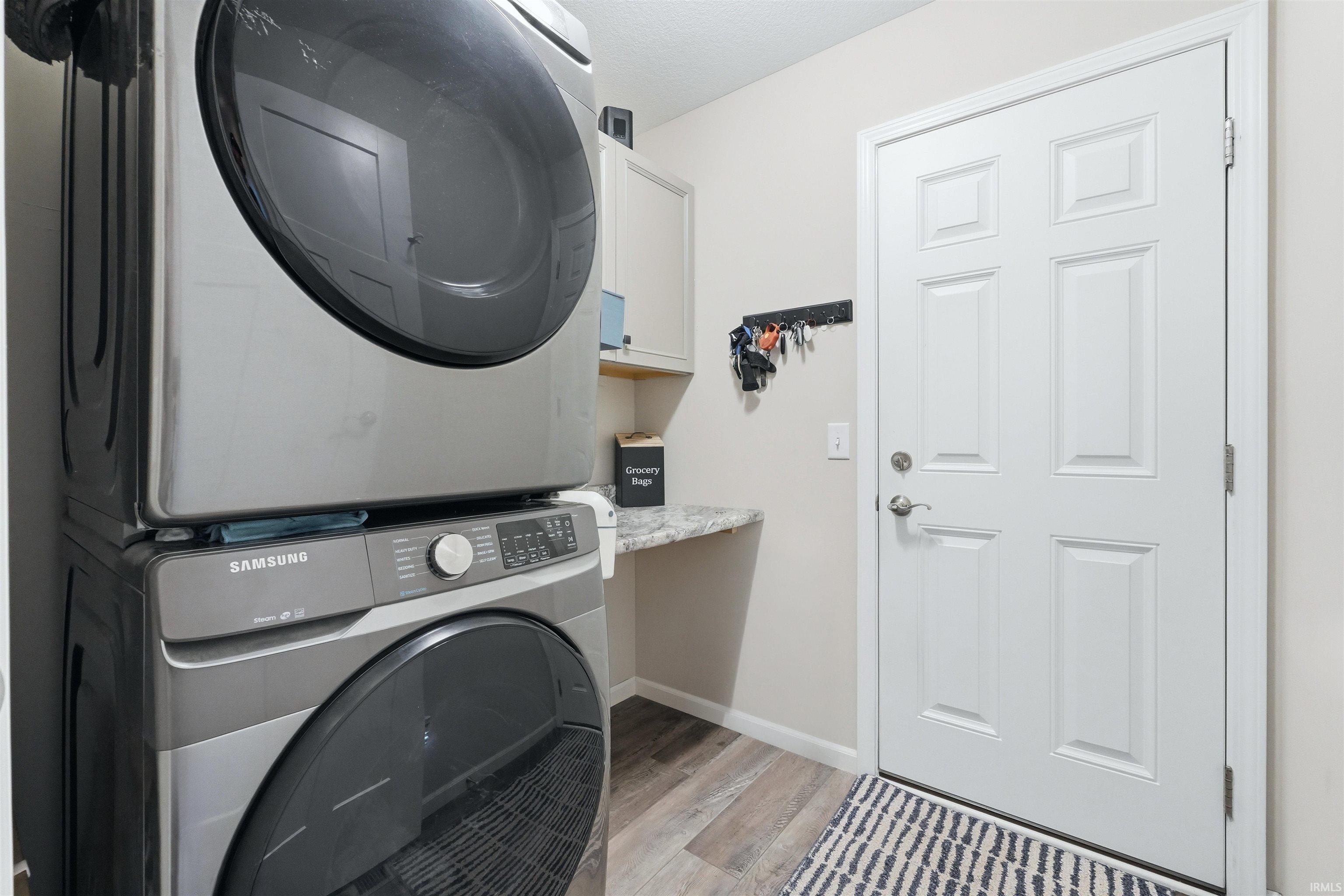 Laundry area with wood-finish flooring and light-toned walls