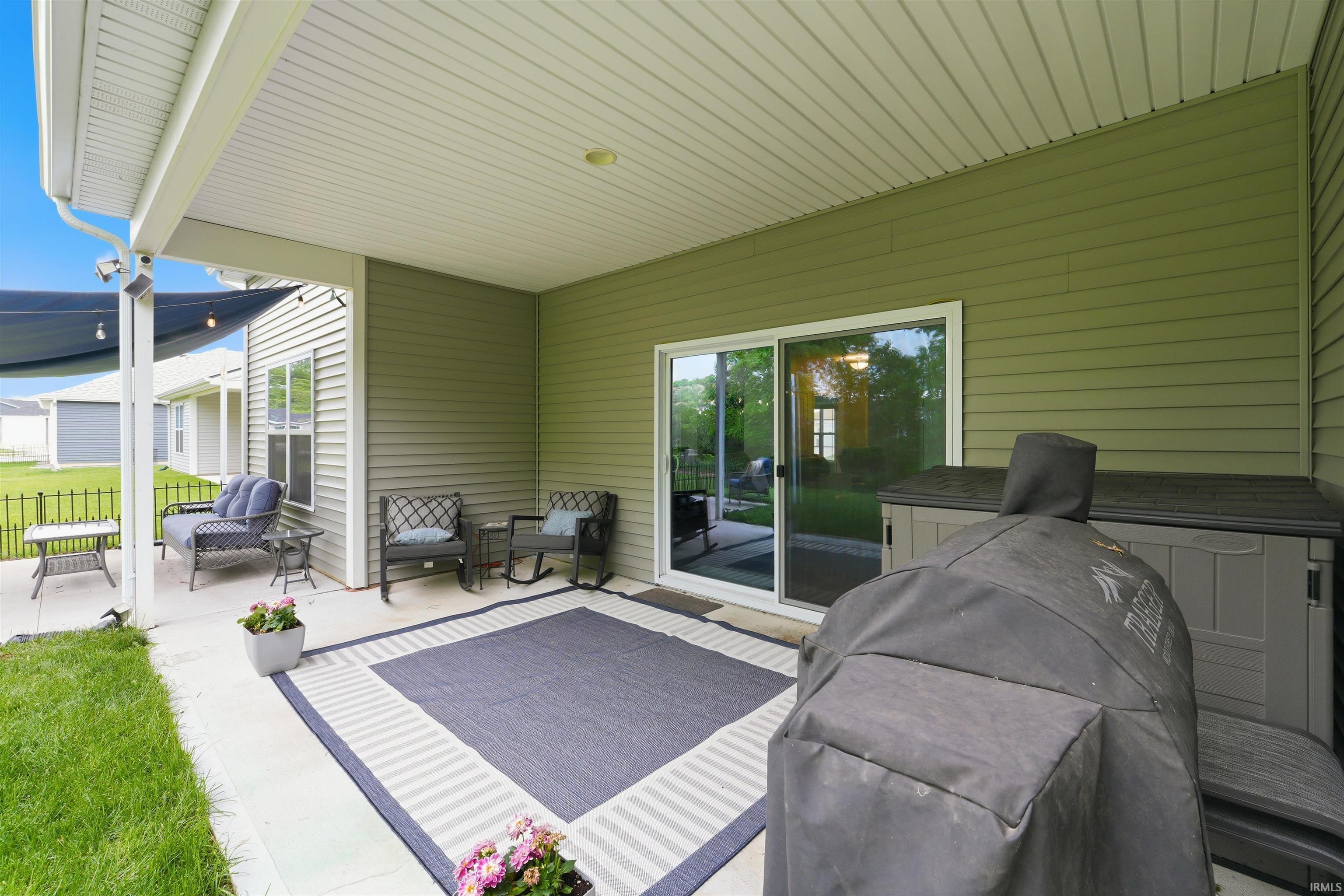 Covered patio featuring a sliding glass door, overhead lighting, and a concrete surface