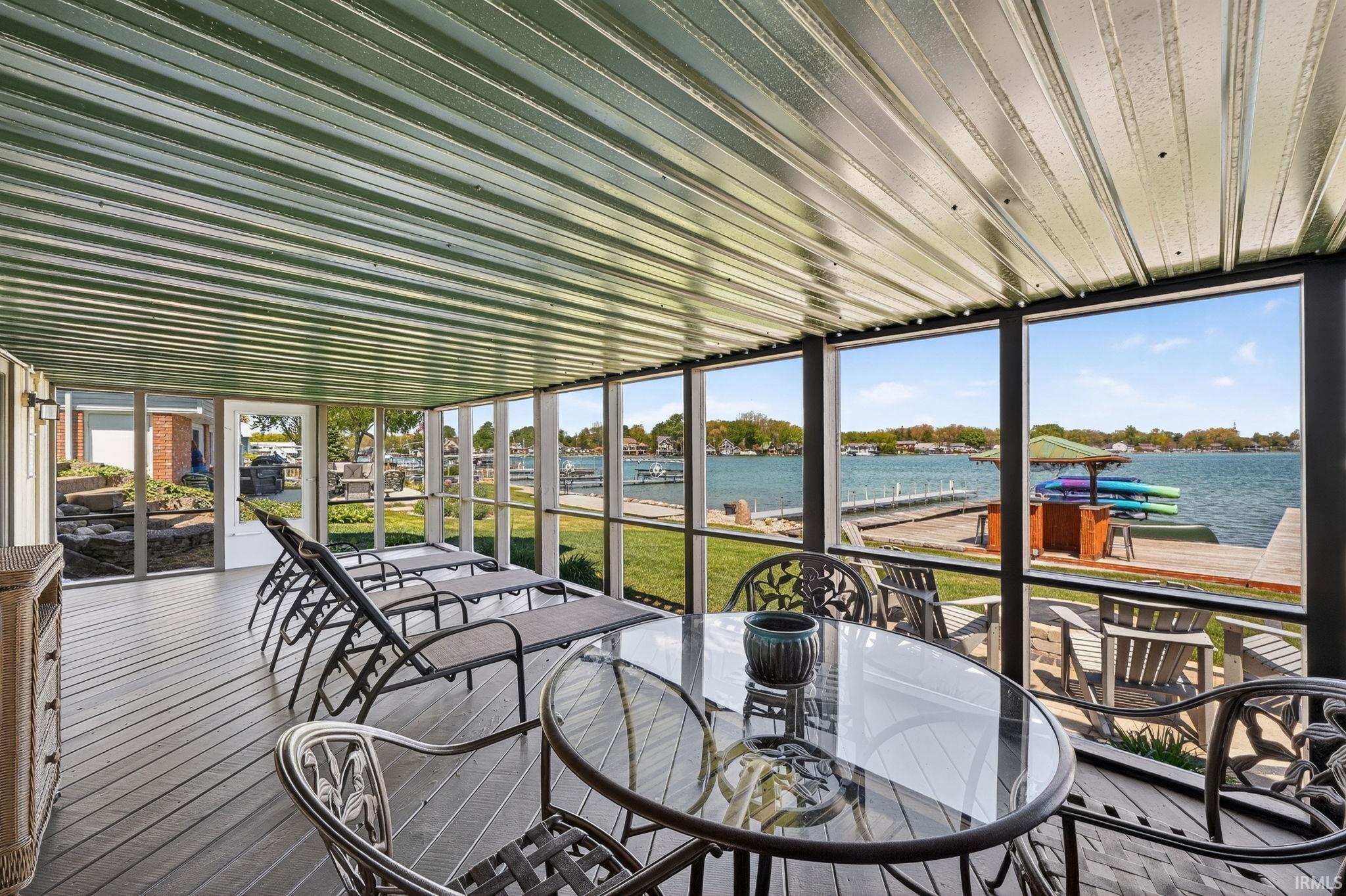 Expansive screened porch with a durable green corrugated ceiling and gray wood-finish decking