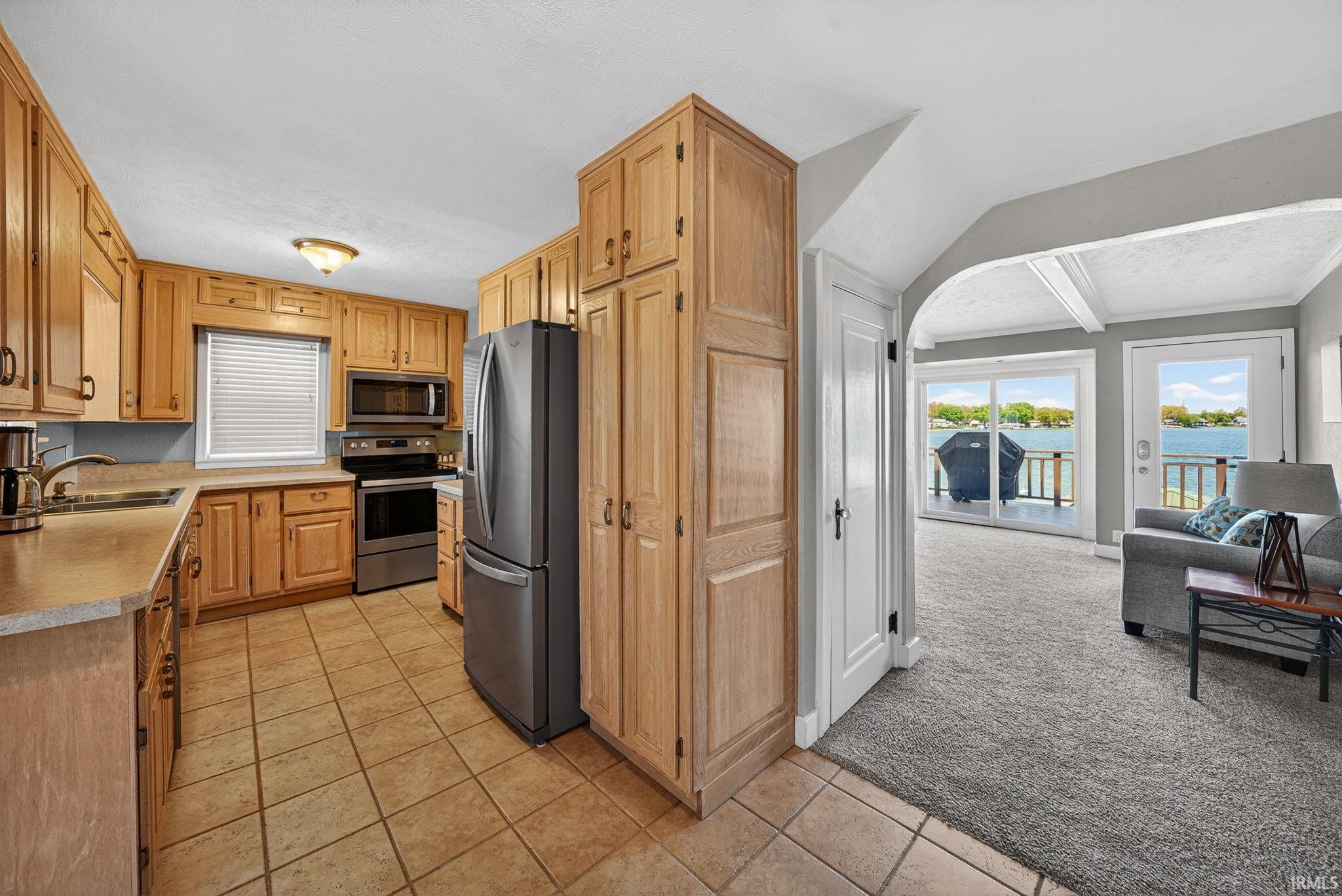 Kitchen featuring wood cabinetry, stainless steel appliances, and tile flooring