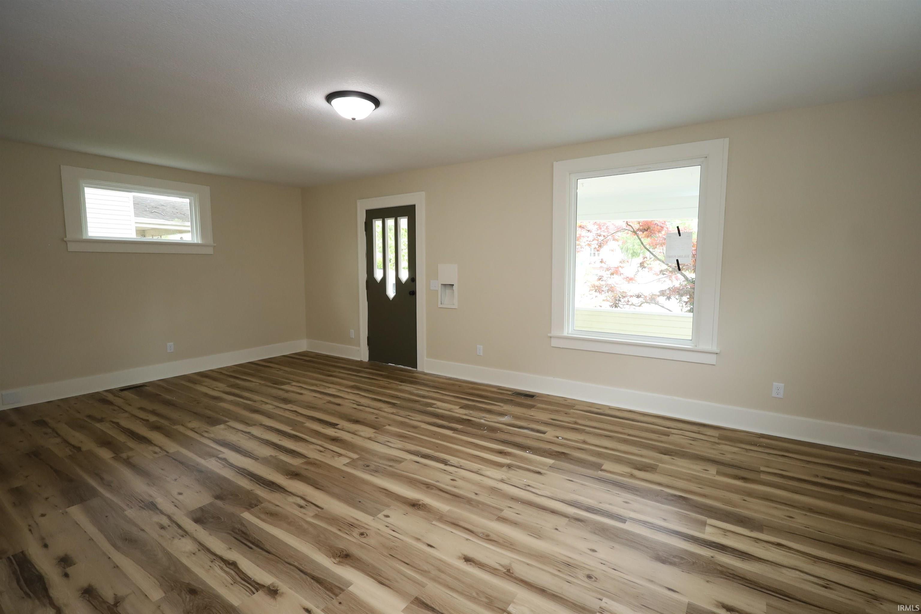 Interior space featuring wood-finish flooring, neutral wall paint, and white trim