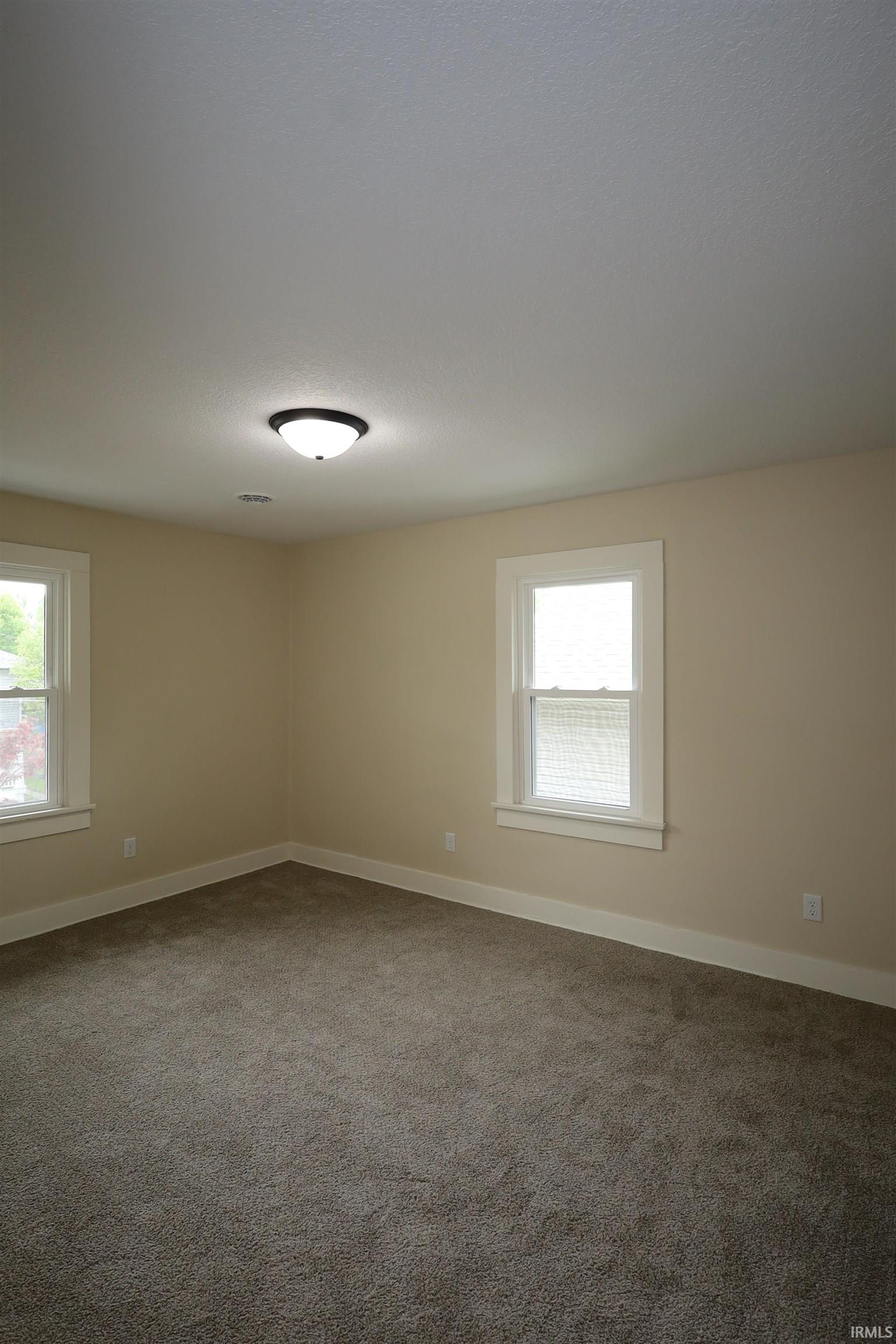 Neutral-toned walls complement the textured gray carpeting