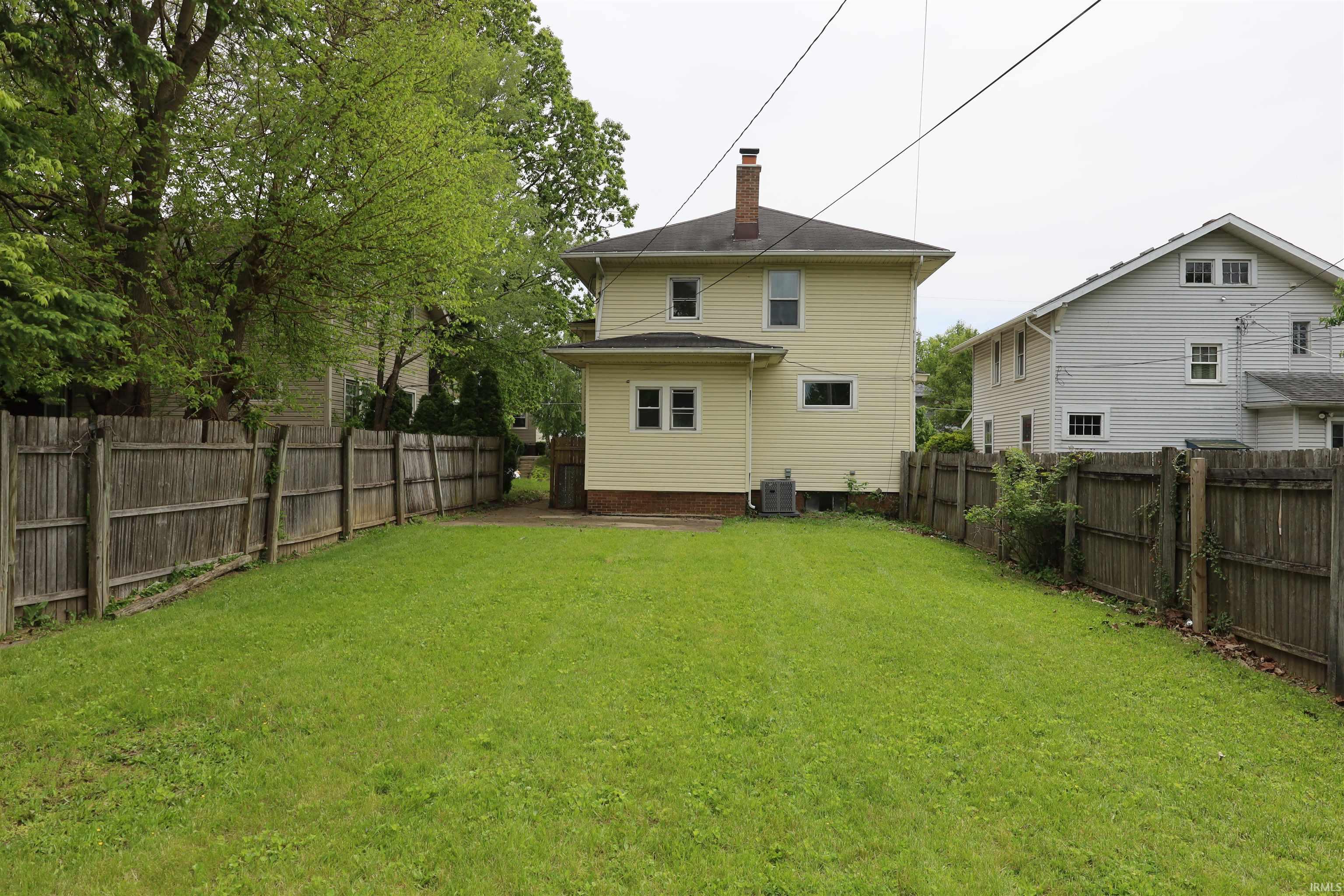Expansive grassy lawn bordered by a wood fence, offering a private outdoor space