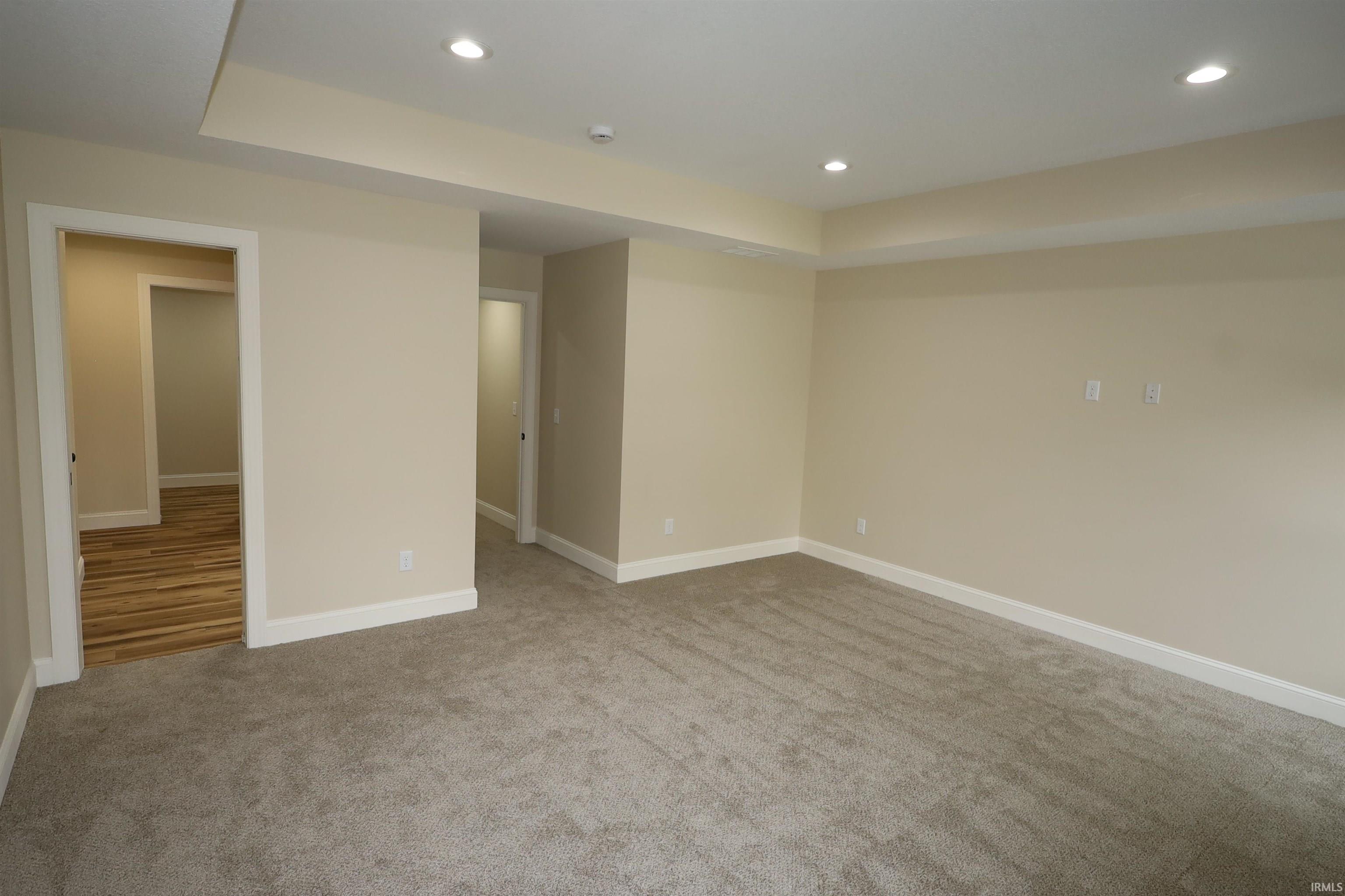 Spacious room featuring neutral carpeting and recessed lighting