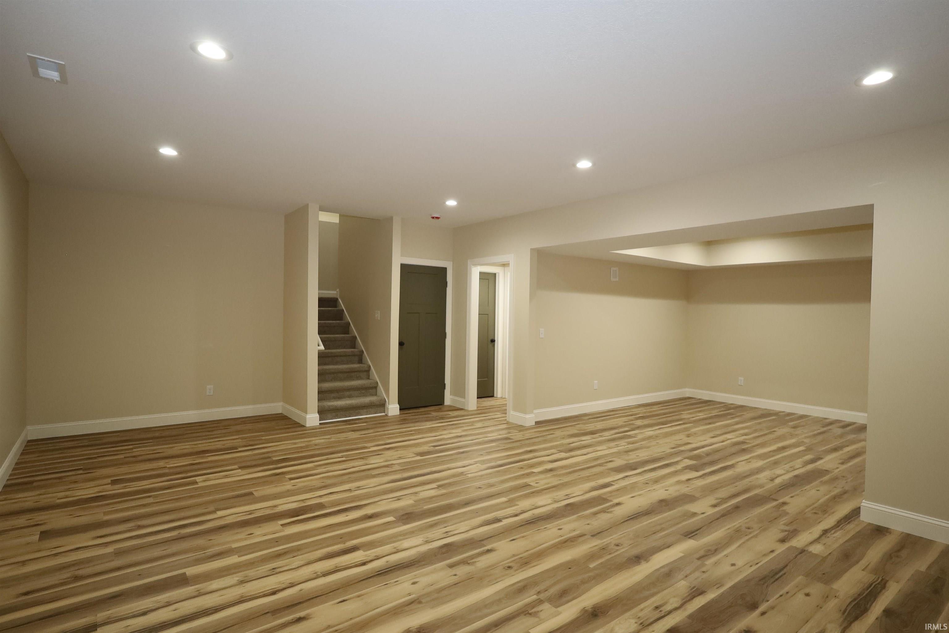 Spacious finished room featuring wood-finish flooring, recessed lighting, and light-toned walls