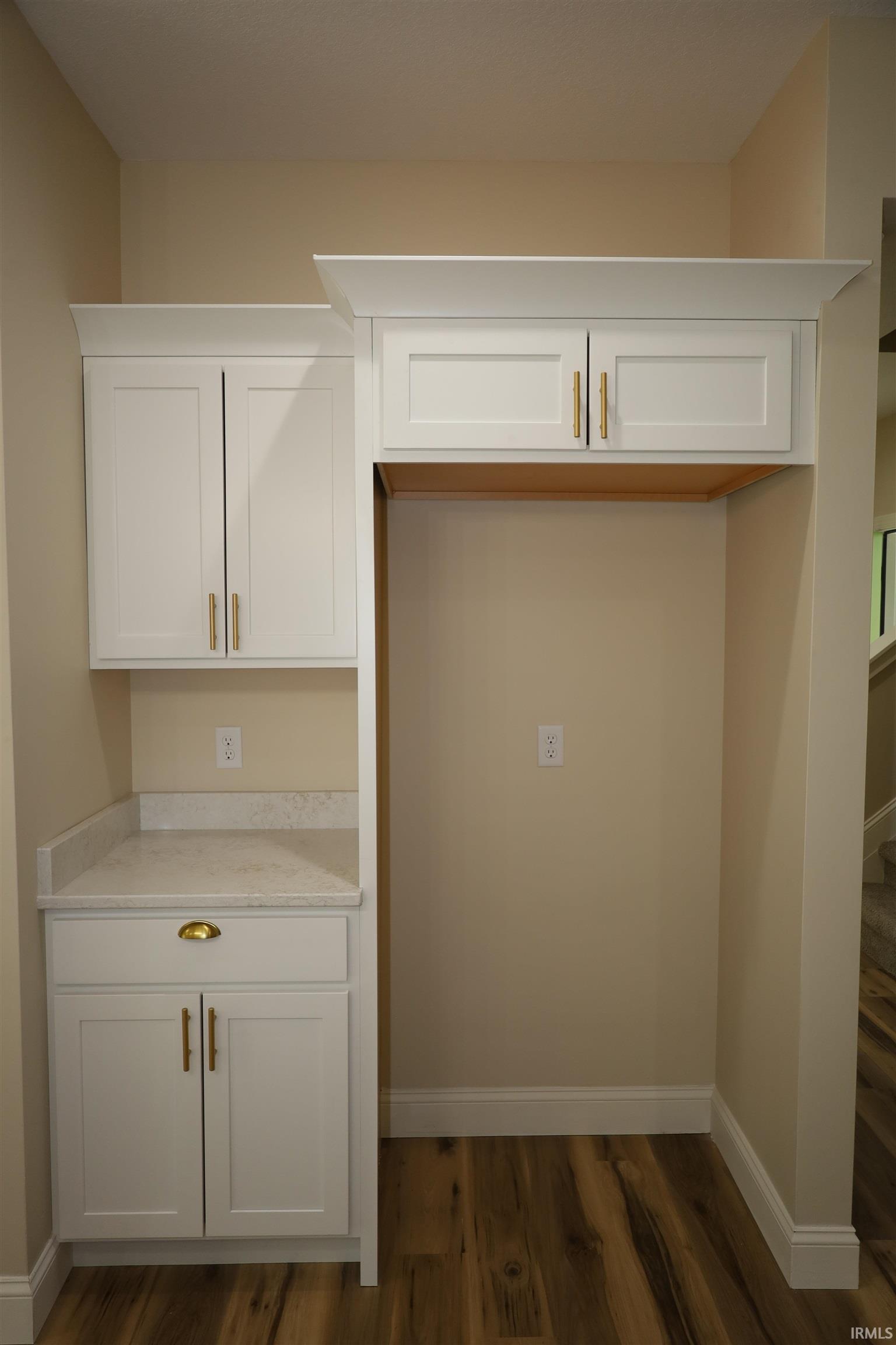 Custom cabinetry featuring white shaker-style doors and brass-tone hardware