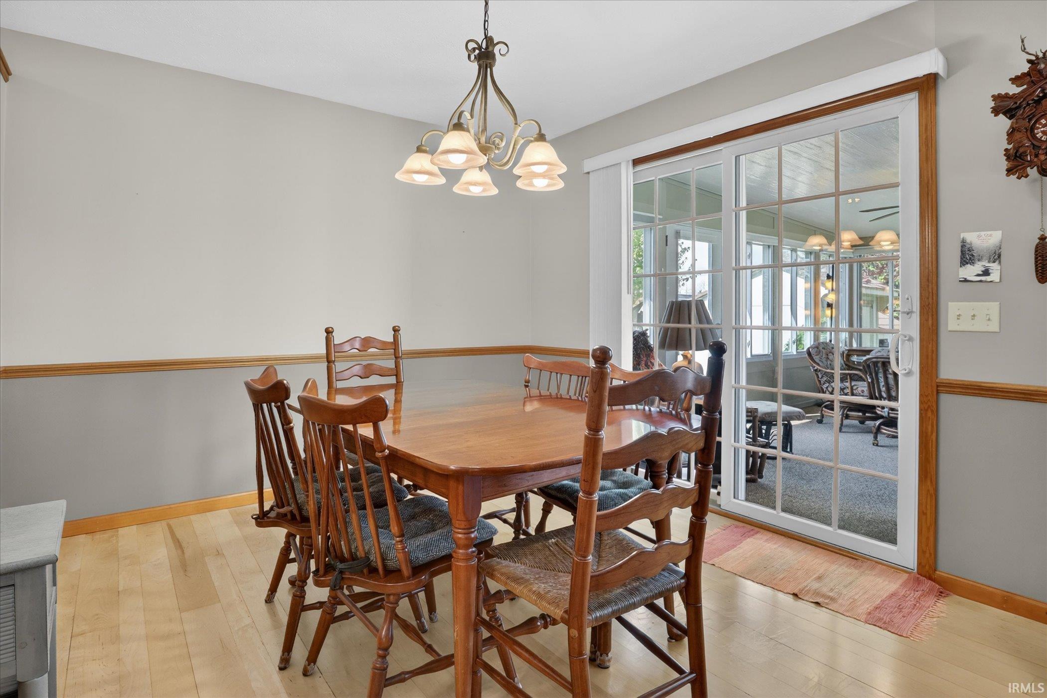 Dining area featuring light wood-finish flooring and a decorative chandelier