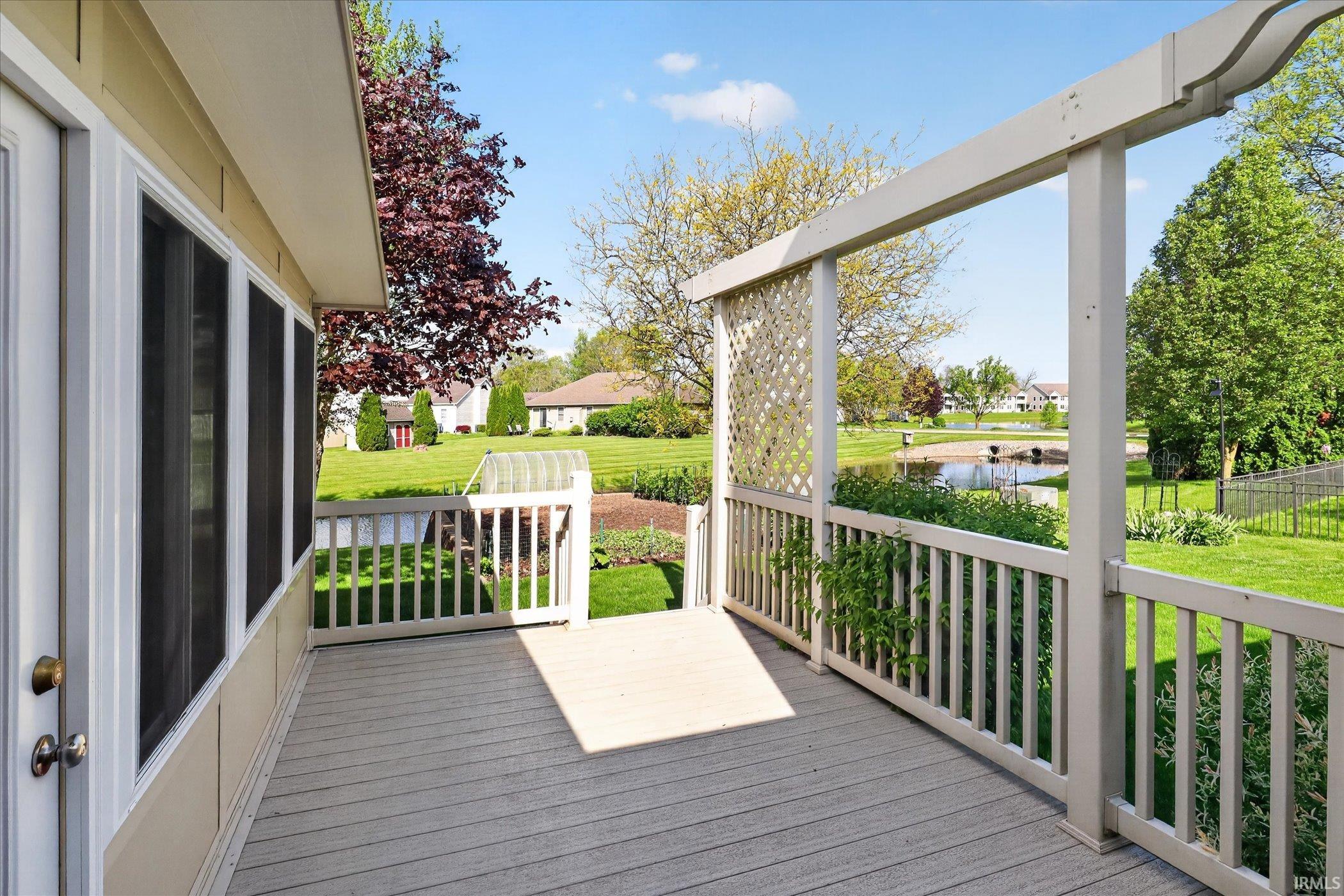 Expansive composite deck featuring a pergola, white railing, and lattice detailing