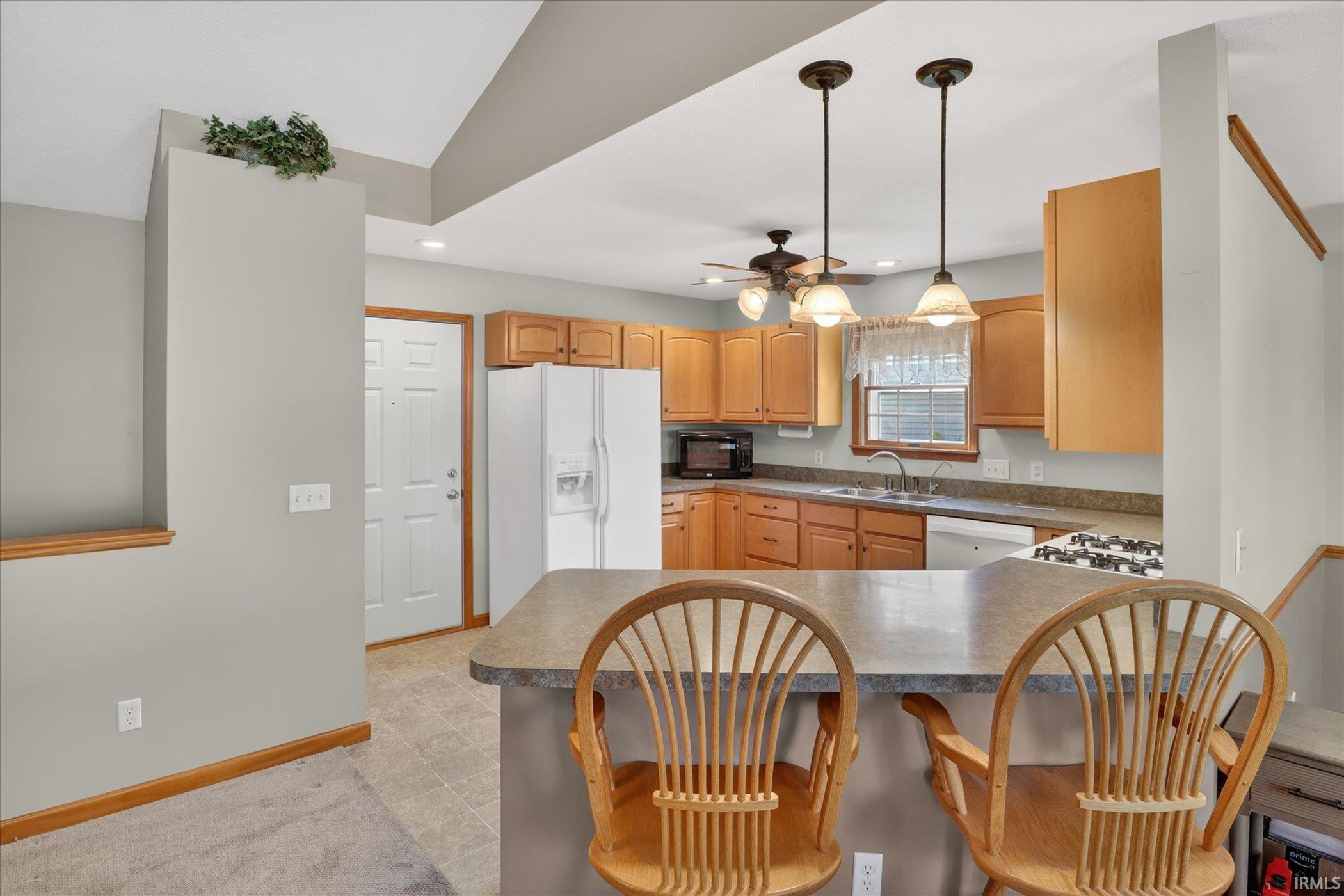 Kitchen featuring wood-finish cabinetry, neutral countertops, and tile flooring