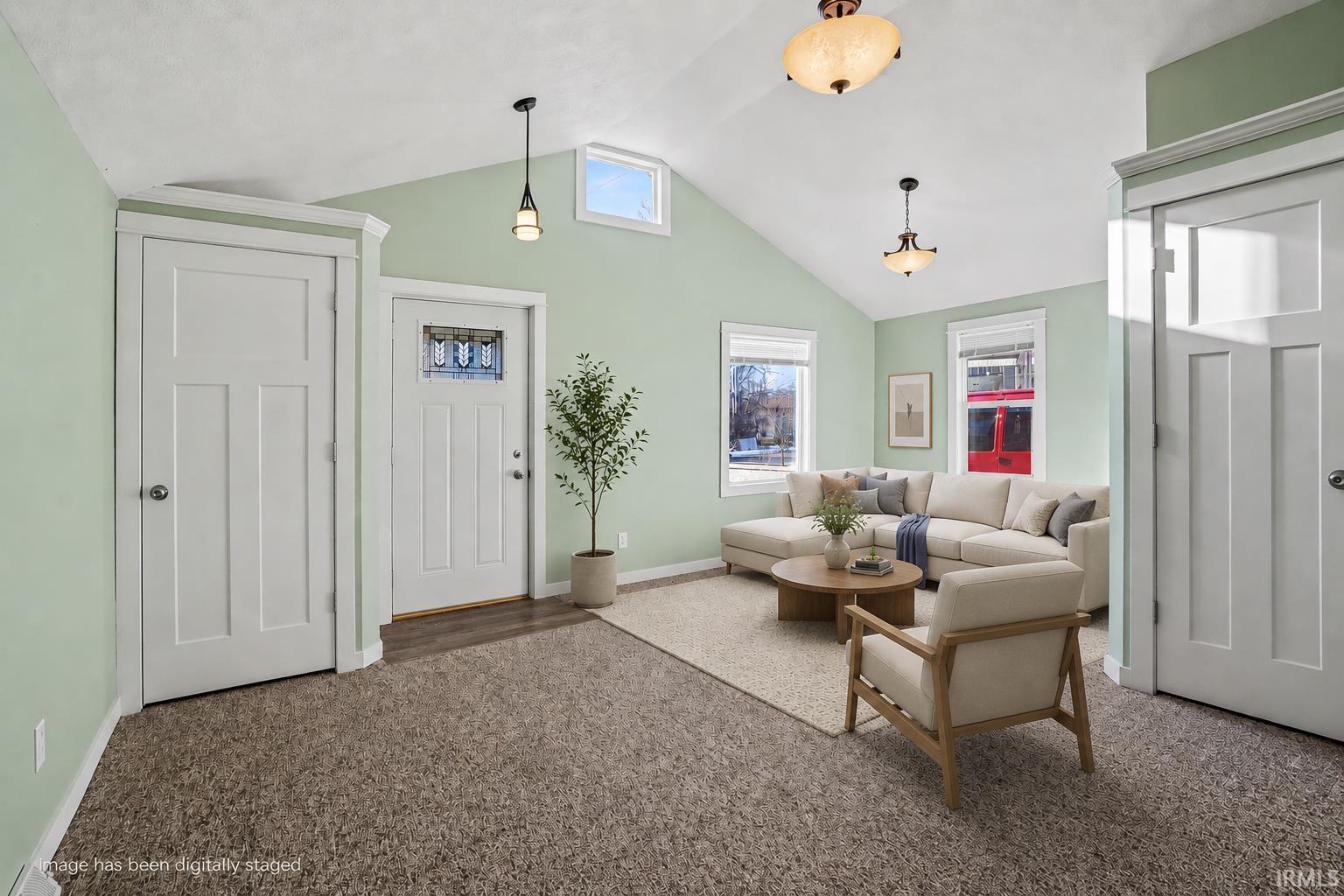 Vaulted ceilings enhance this living area, complemented by light green walls and white trim