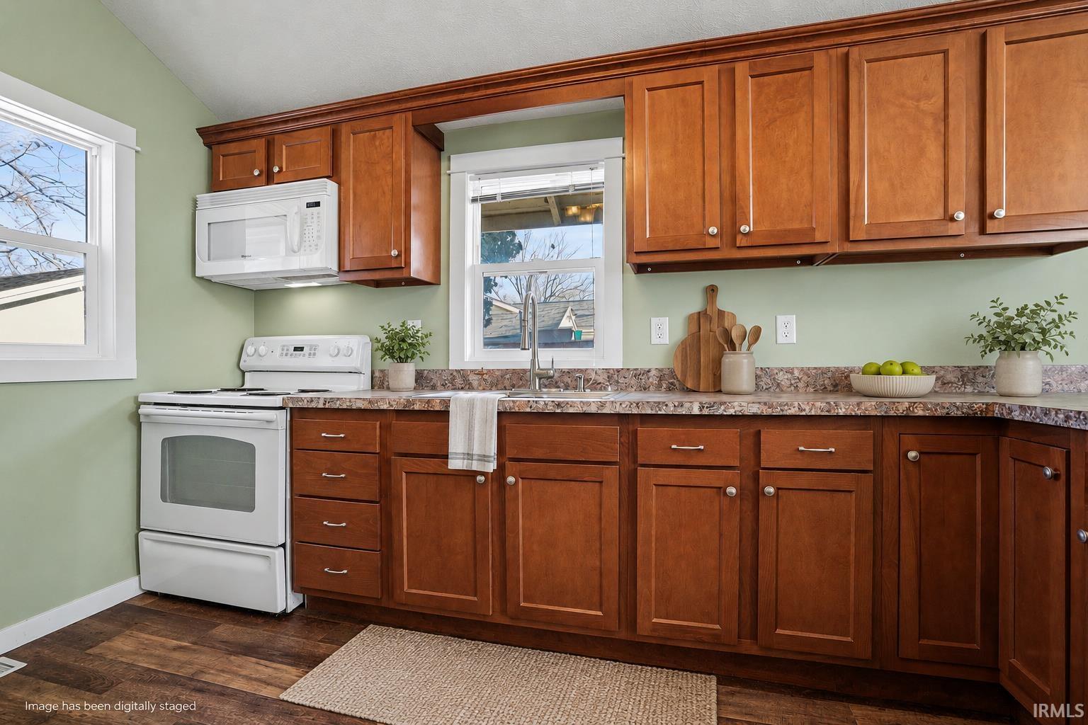 Kitchen featuring wood-finish cabinetry, laminate countertops, a white electric range, and an over-the-range microwave