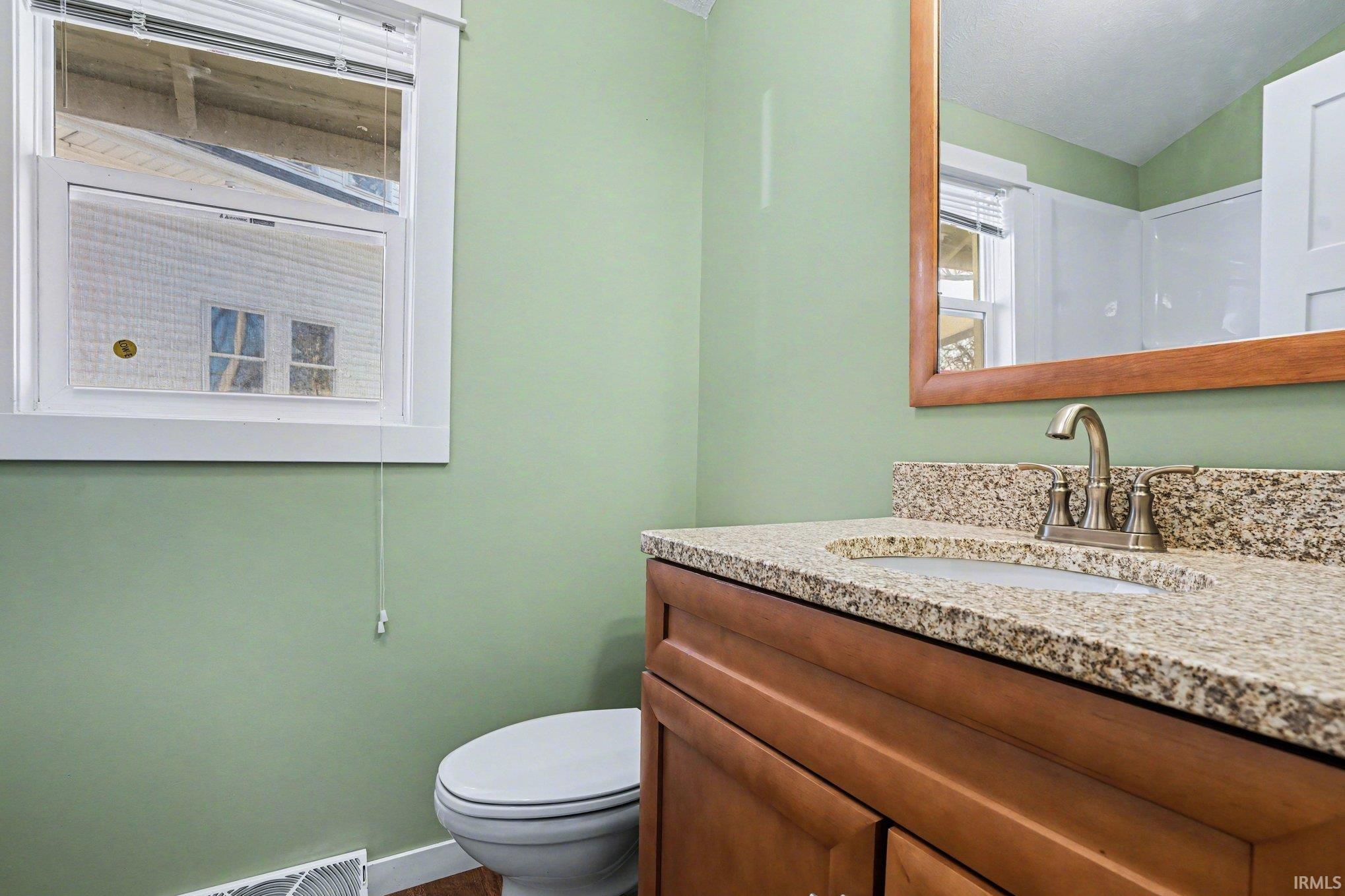 Bathroom featuring vanity and vaulted ceiling