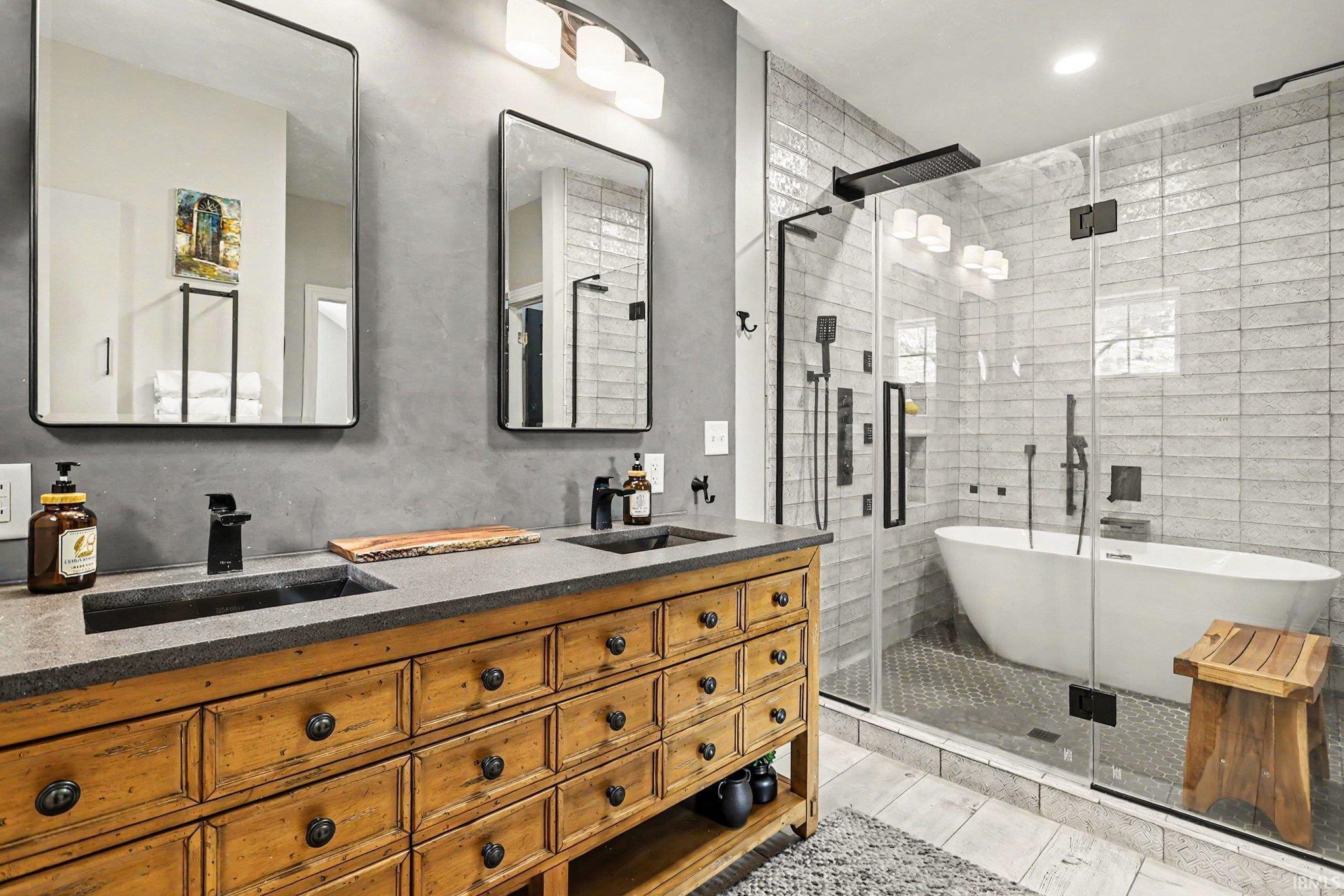 Freestanding soaking tub with a tiled shower enclosure and glass paneling