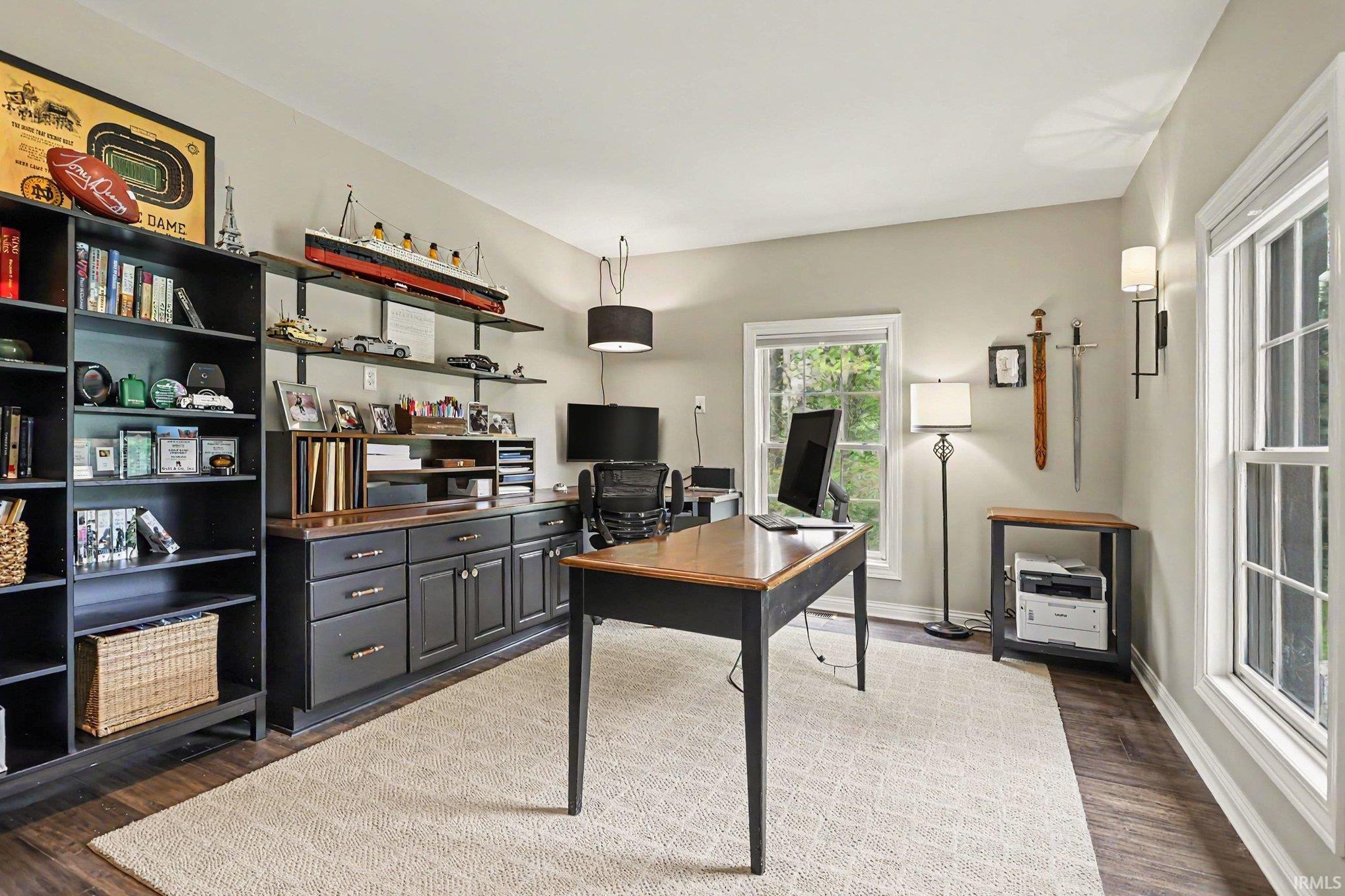 Dedicated room featuring wood-finish flooring and two distinct window installations