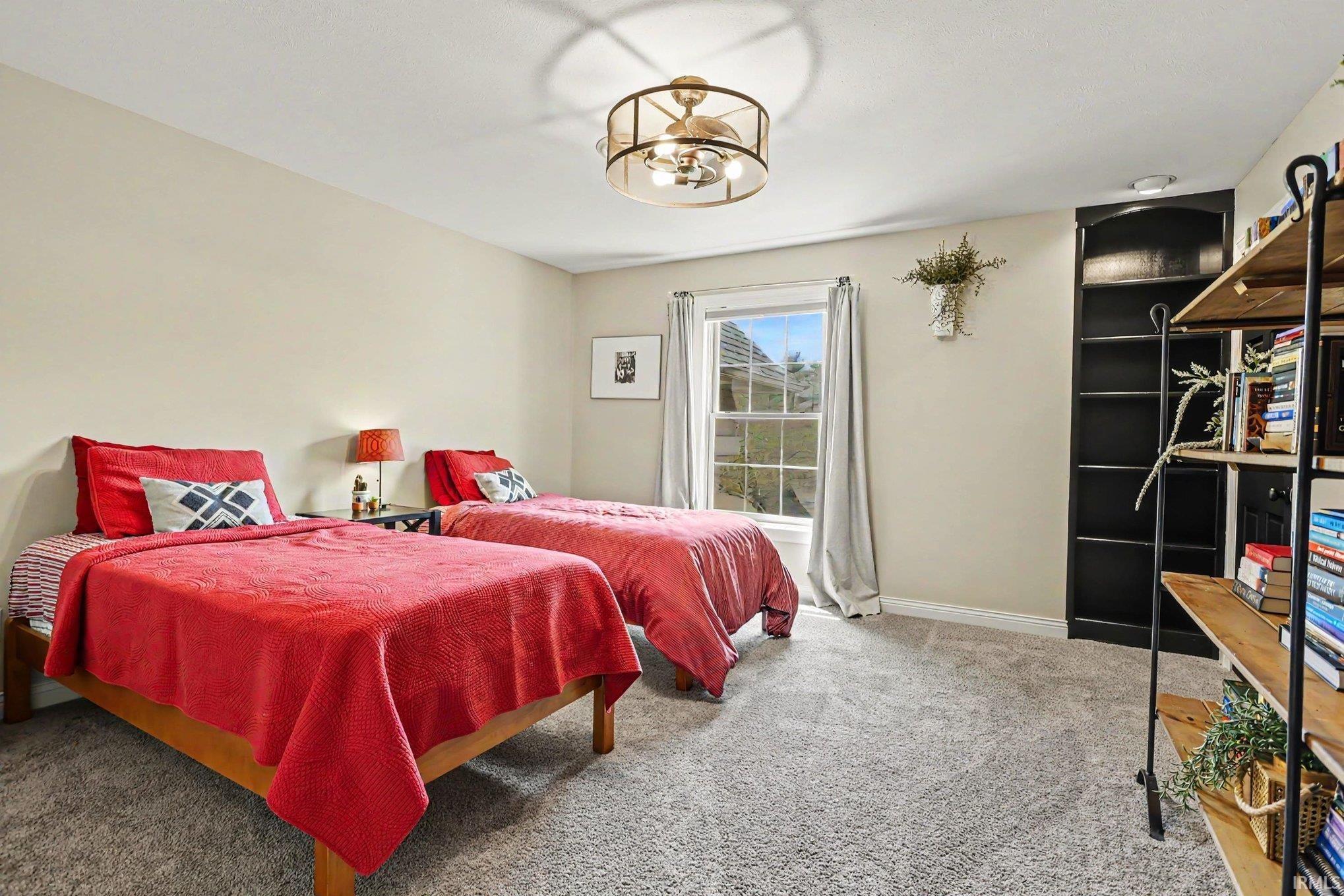 Windowed room featuring neutral wall paint, light gray carpet, and a ceiling fan with integrated lighting