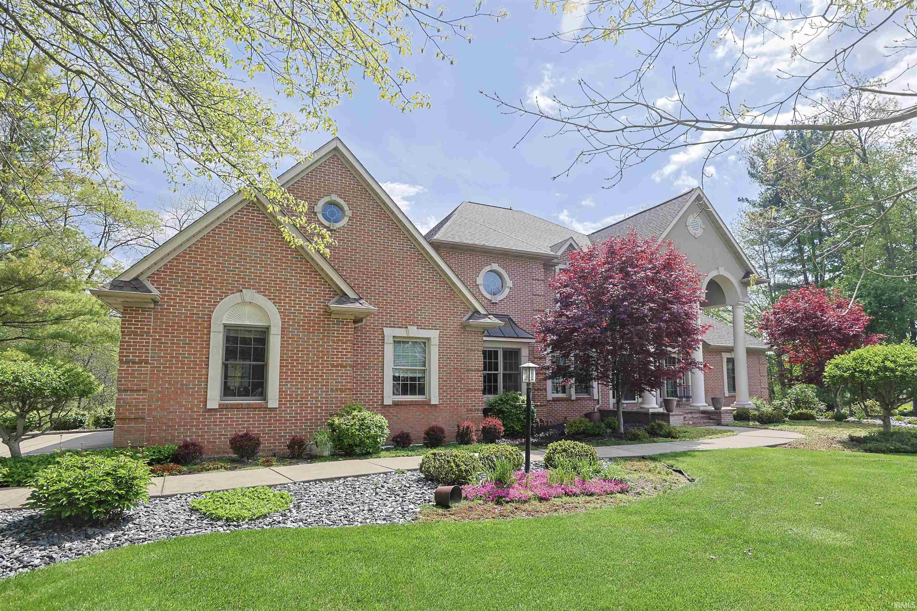 Brick exterior featuring a portico entry with columns