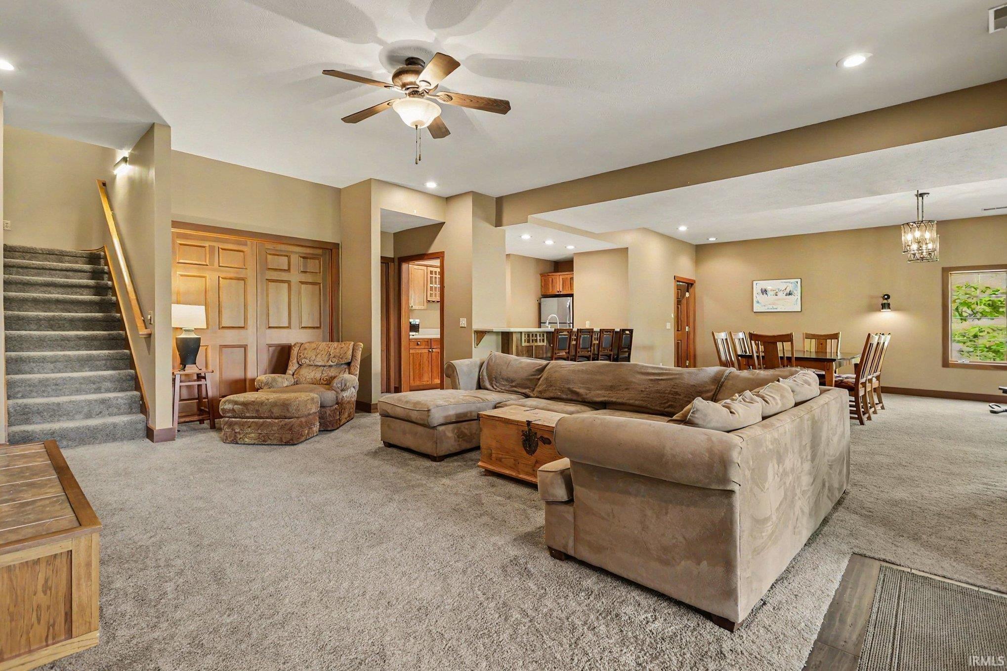 Spacious lower-level area with neutral carpeting and recessed lighting