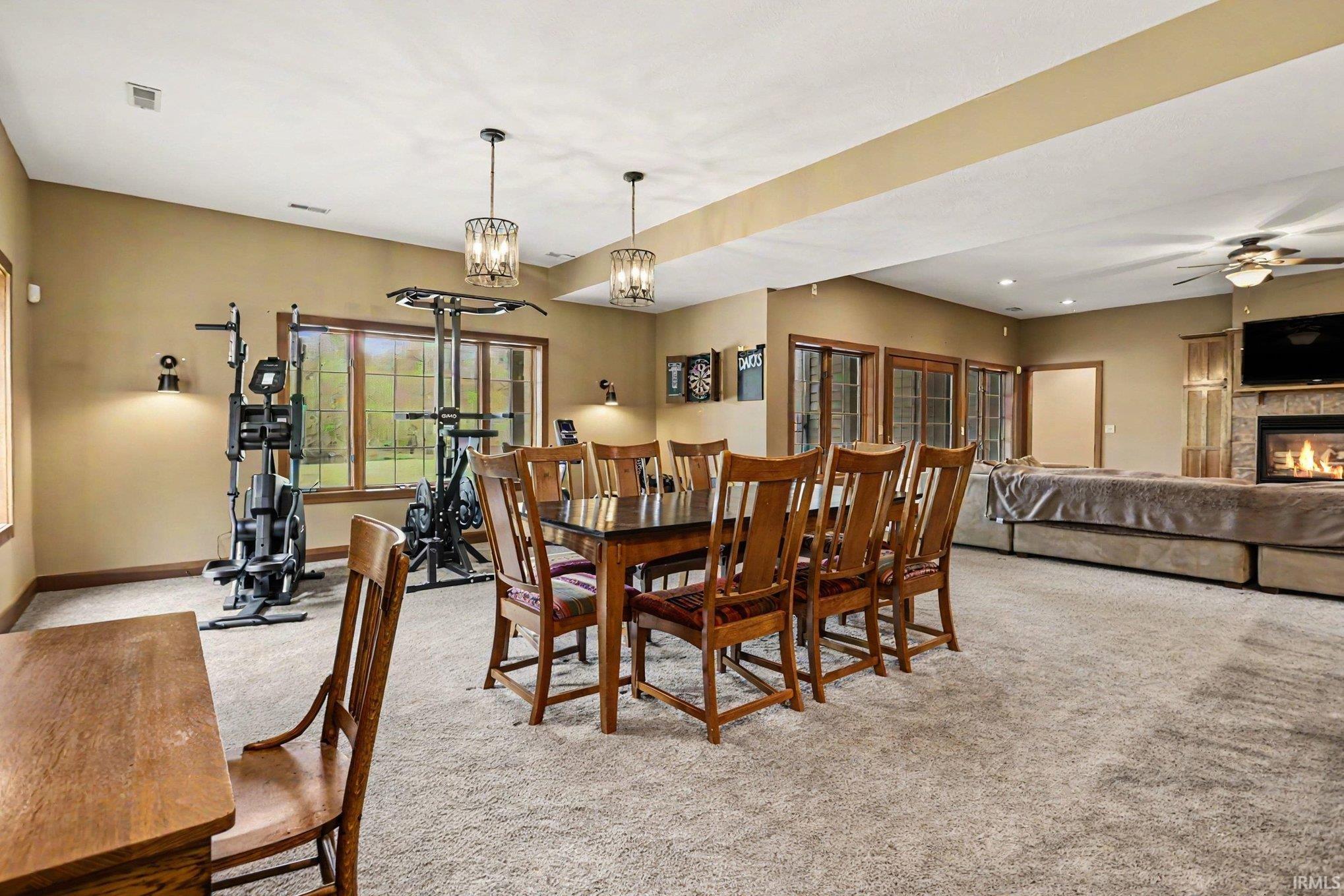 Spacious lower level featuring plush carpeting, recessed lighting, and a stone fireplace with a built-in media cabinet