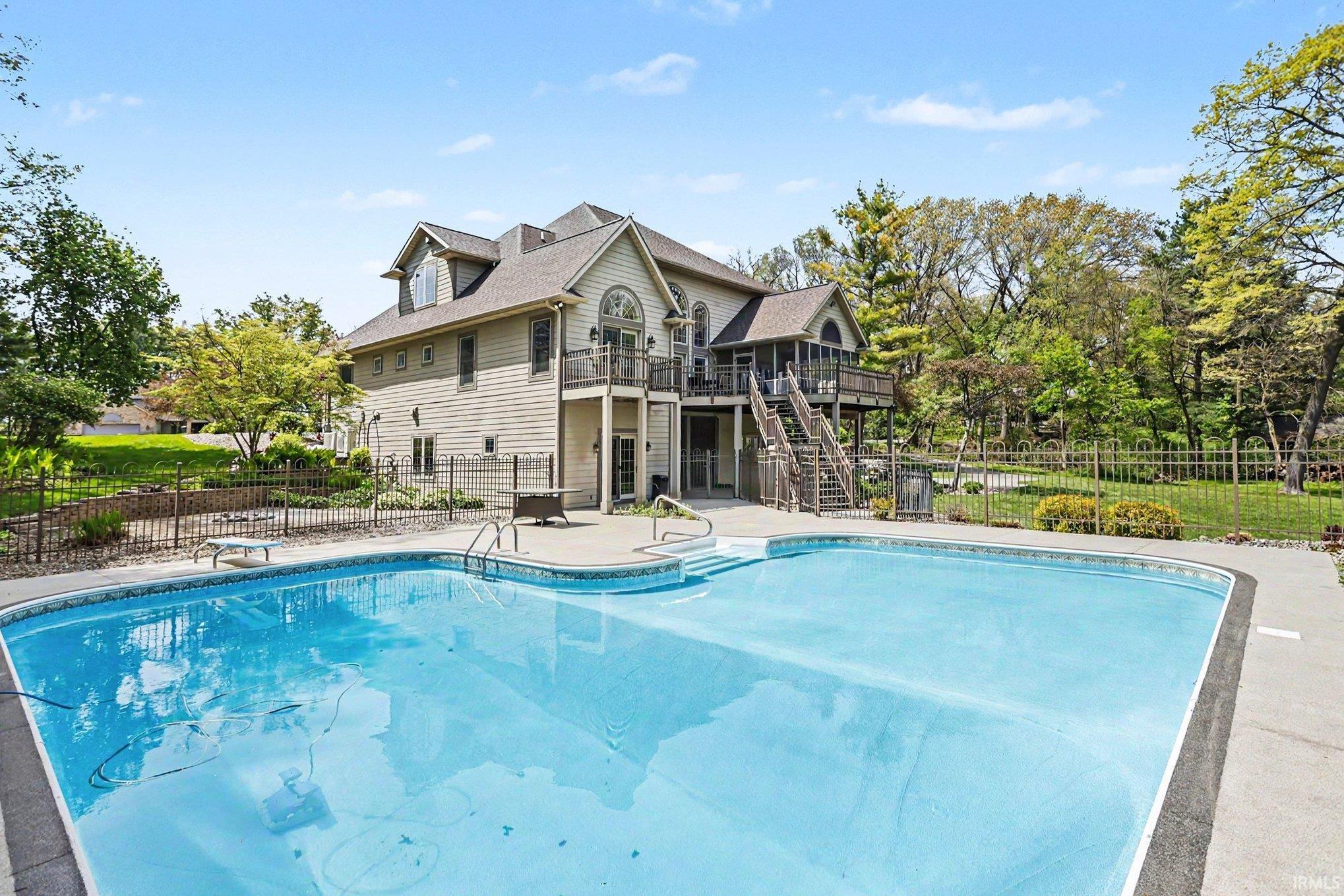 Expansive outdoor pool with integrated steps, surrounded by concrete decking