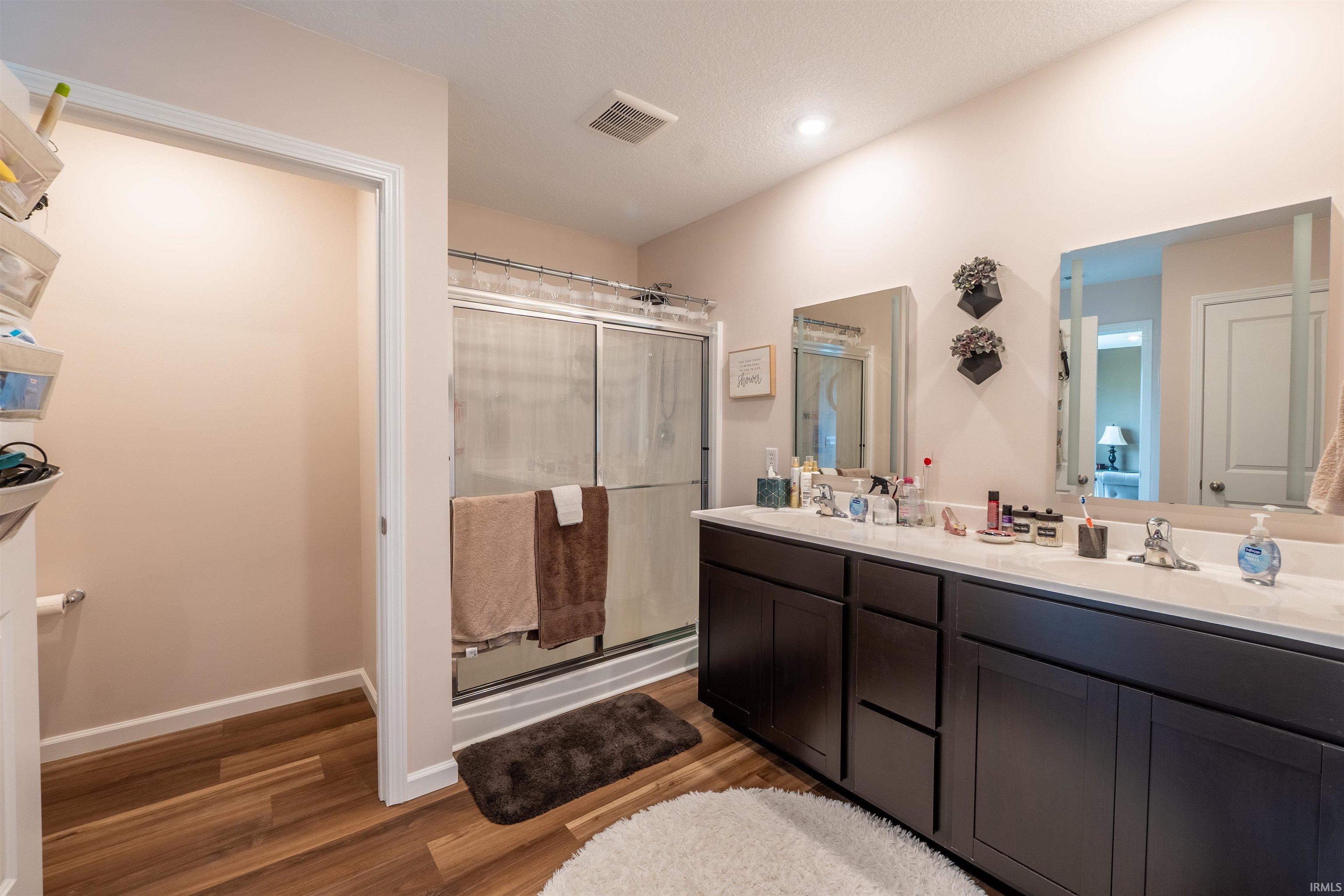Bathroom featuring a double vanity with dark wood-finish cabinetry and white countertops