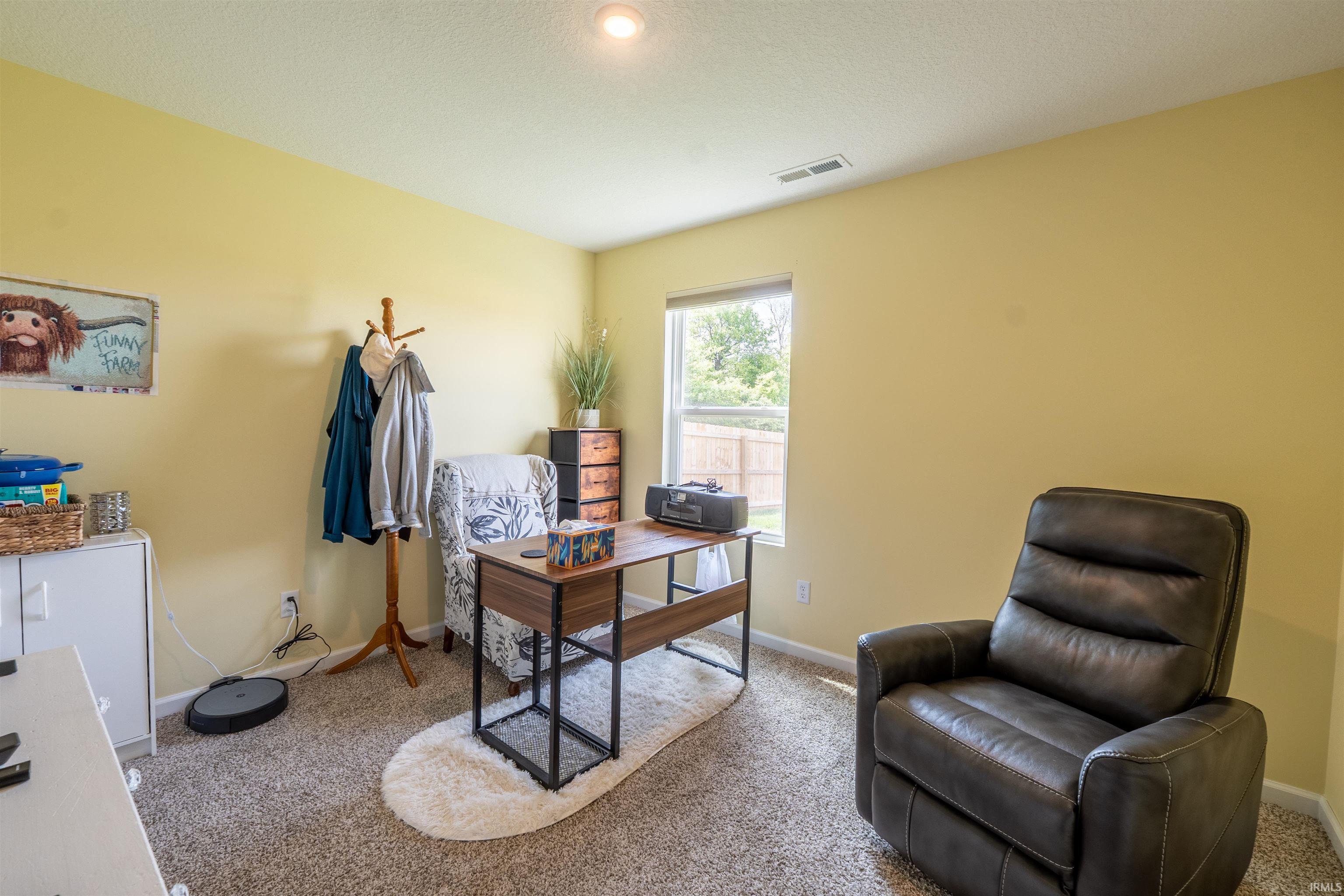 Carpeted room with a single window and recessed ceiling lighting