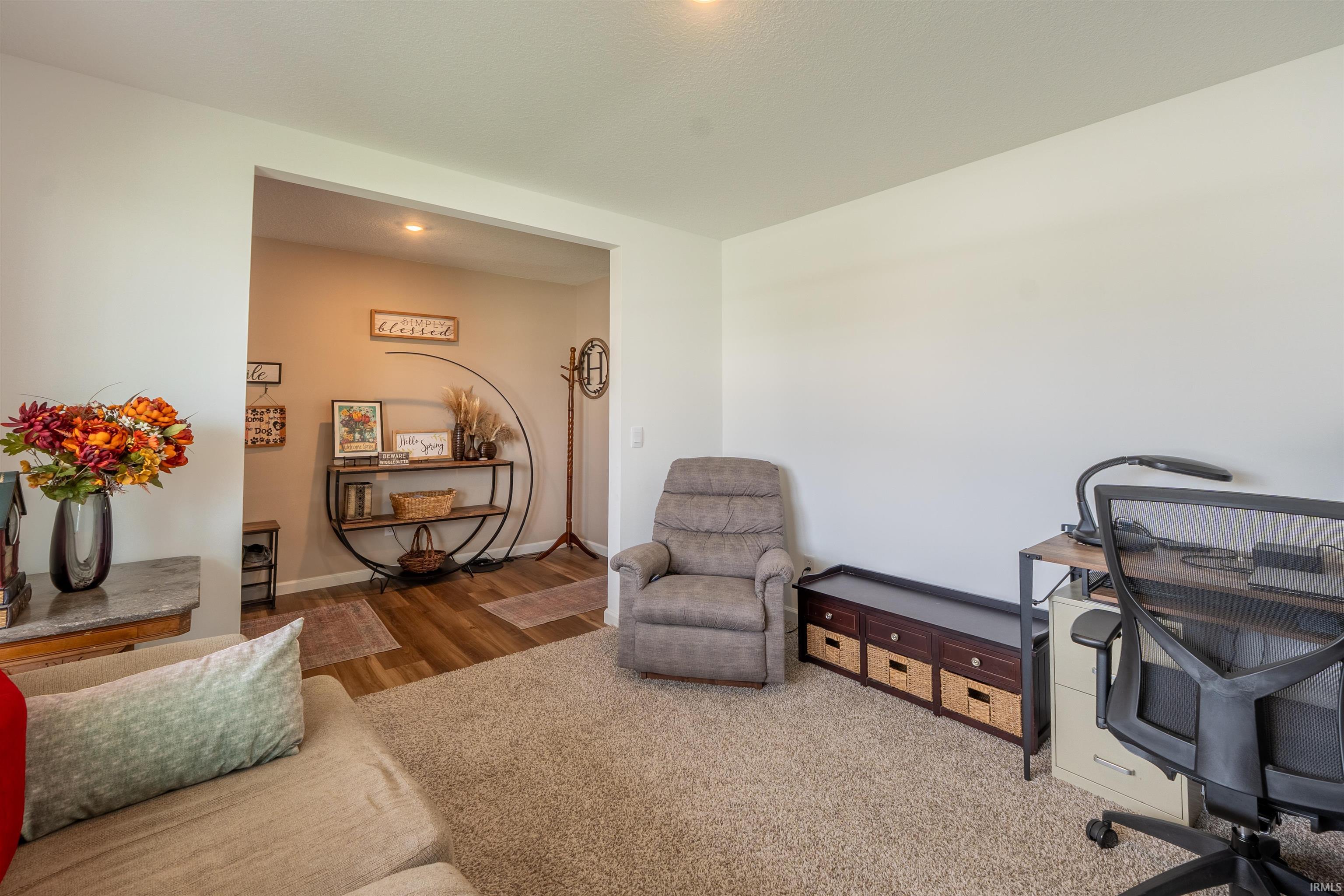 Carpeted interior space featuring a recessed doorway with wood-finish flooring