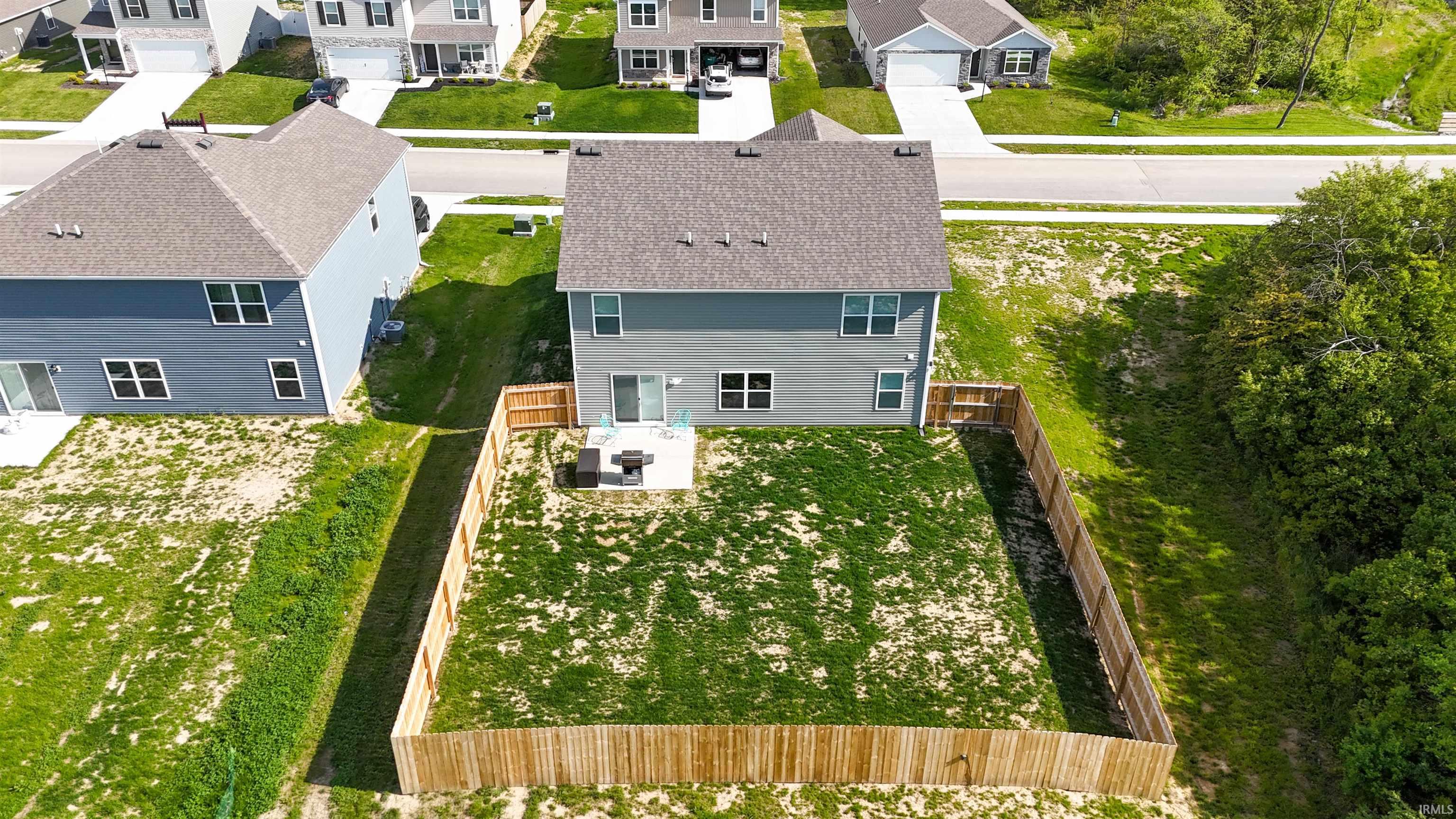 Rear exterior of a two-story residence featuring grey siding and a dark shingle roof
