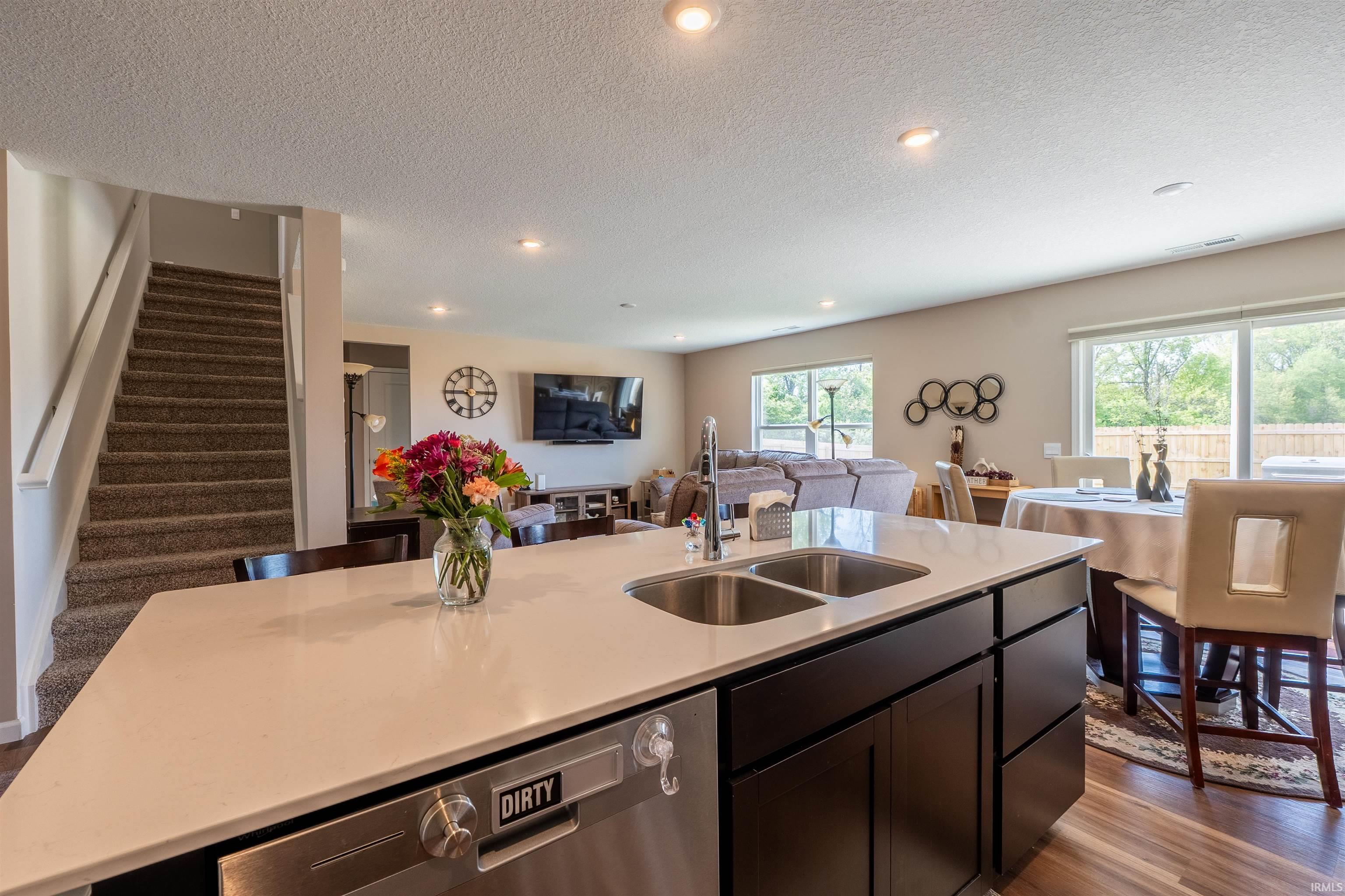 Kitchen island featuring a dual stainless steel sink and integrated dishwasher
