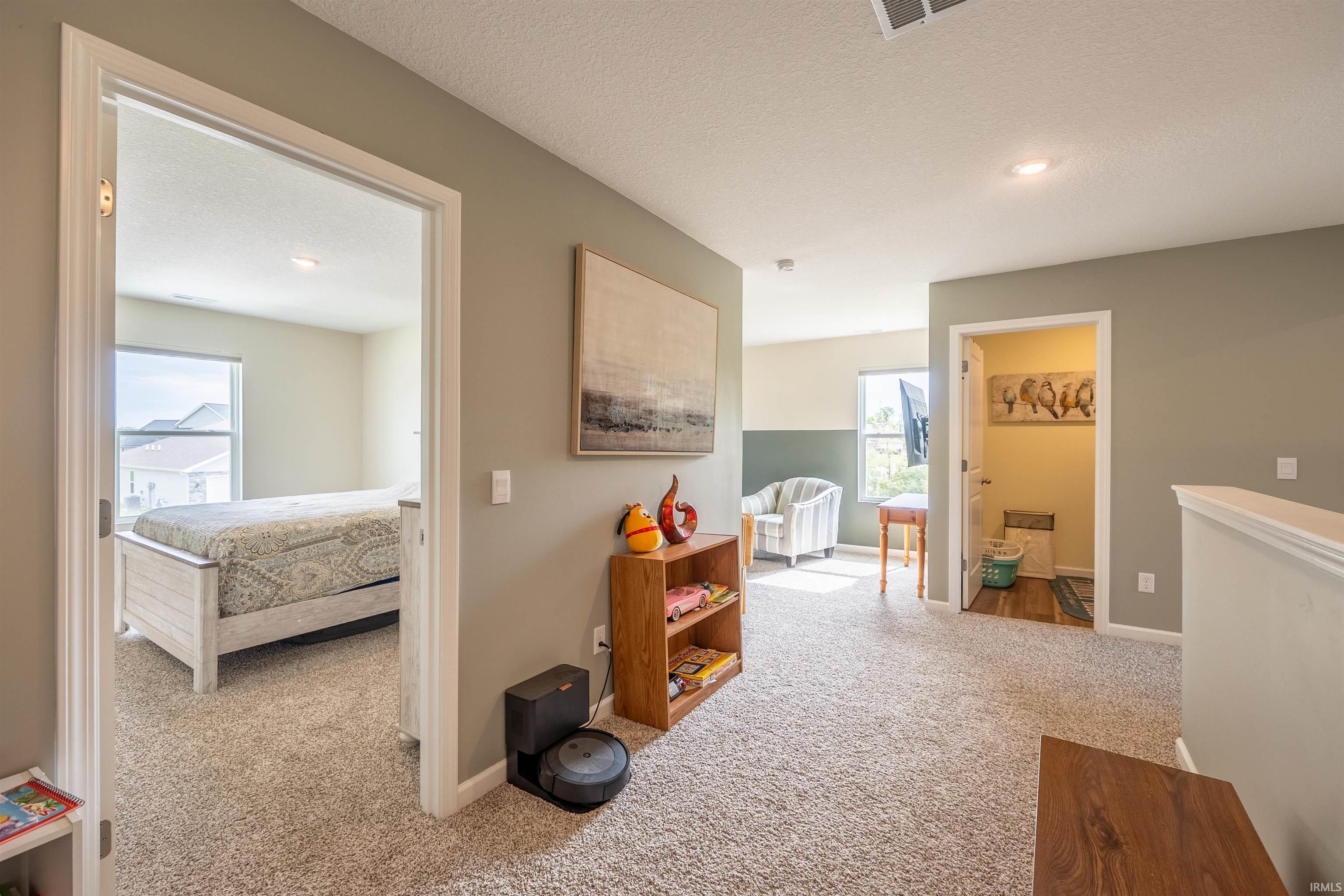 Carpeted upper-level landing with neutral wall colors and a window providing natural light