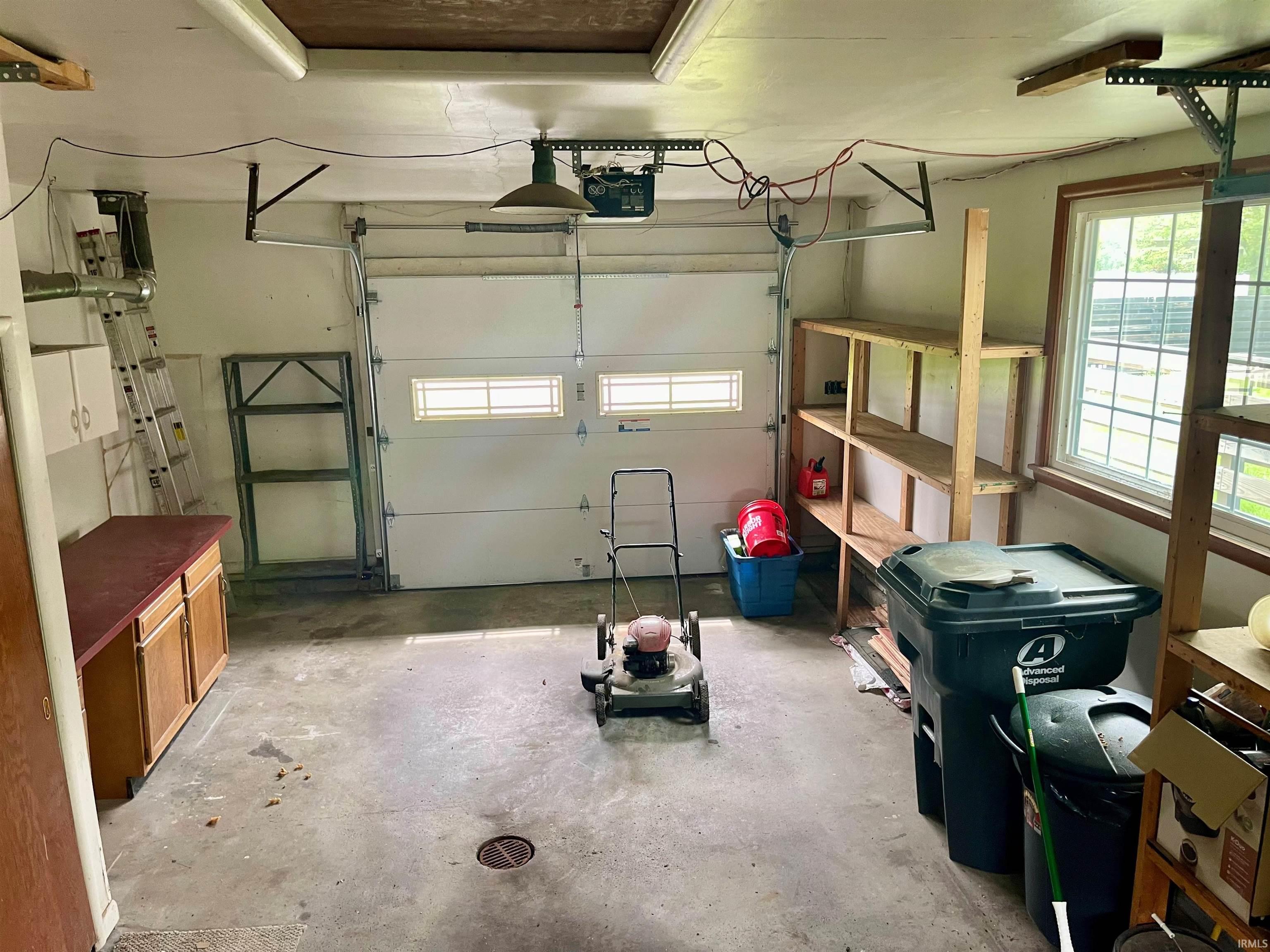 Attached single-car garage featuring a concrete floor and an automatic garage door opener