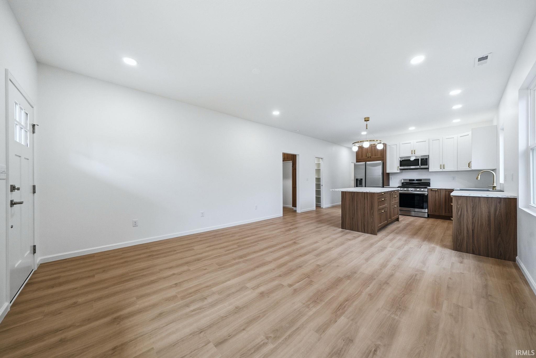 Open-concept featuring wood-finish flooring, recessed lighting, and a modern kitchen