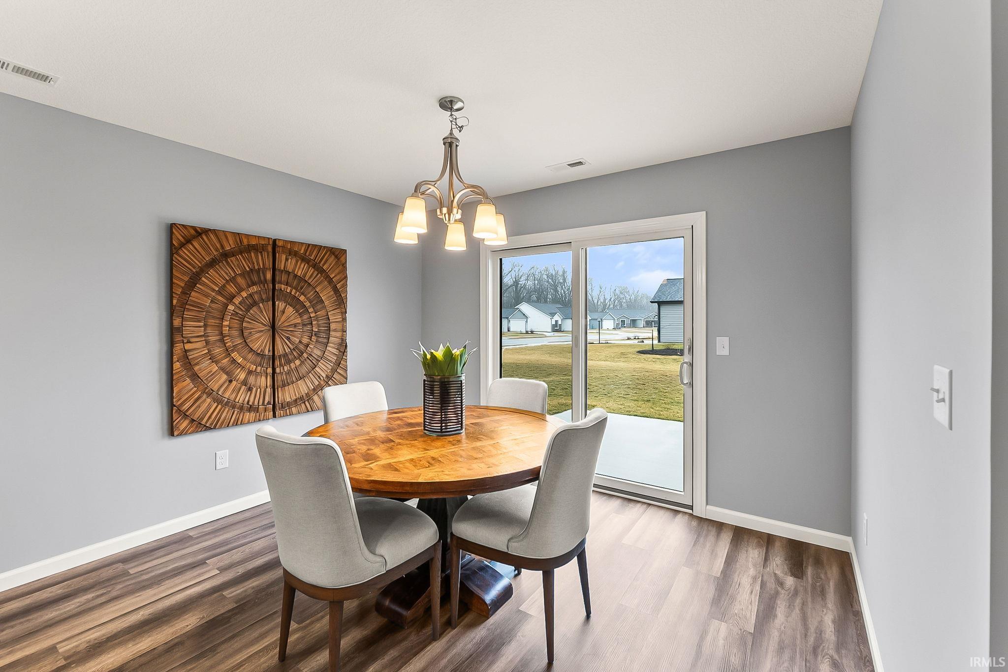 Dining area featuring wood-finish flooring, light gray wall paint, and white trim