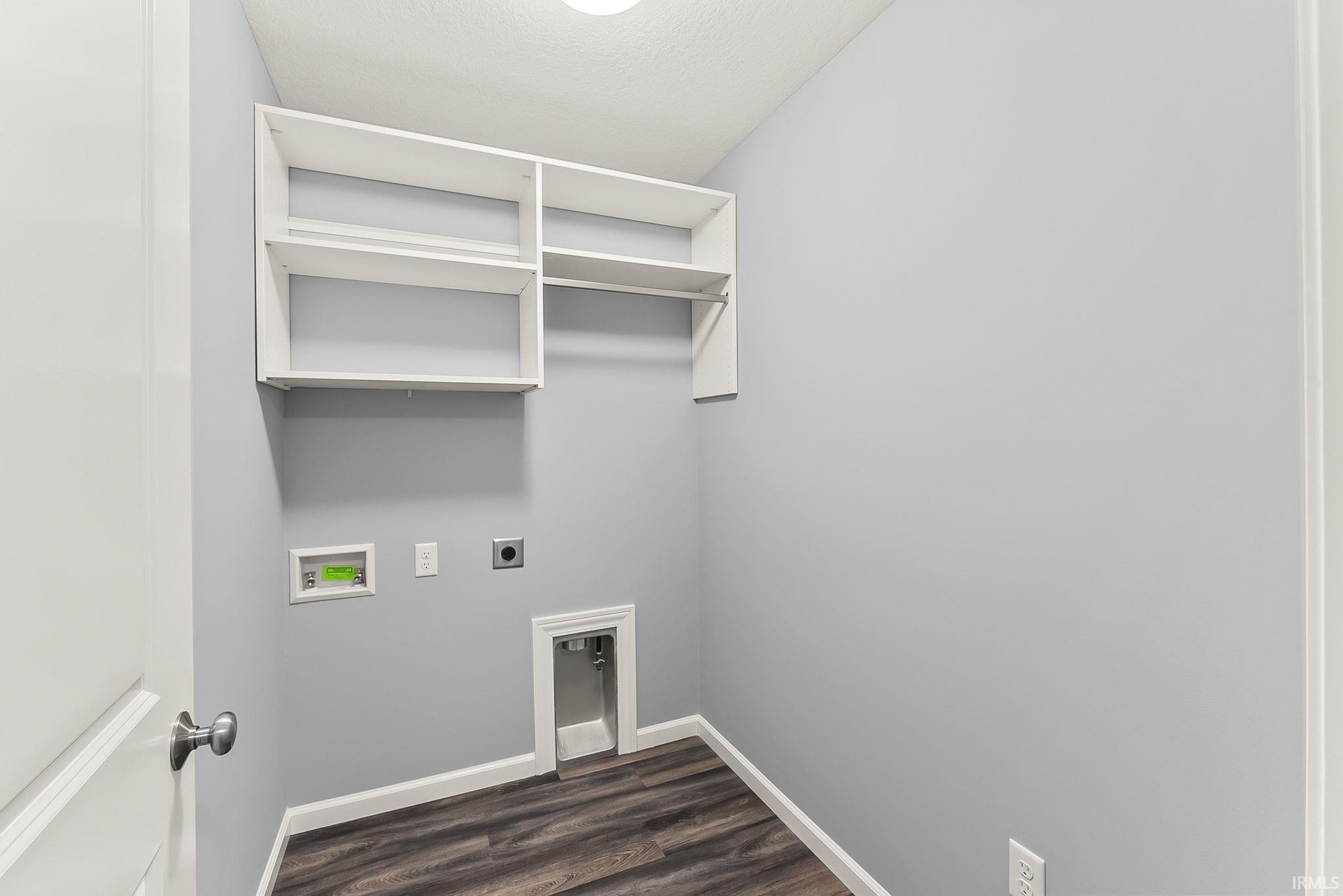 Utility room featuring built-in shelving, wood-finish flooring, and light gray walls