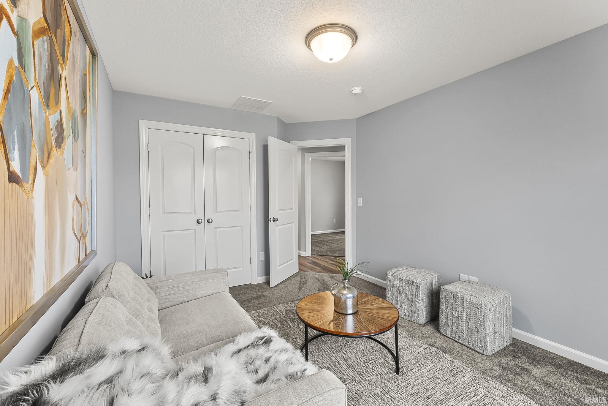 Carpeted interior space featuring light grey wall paint