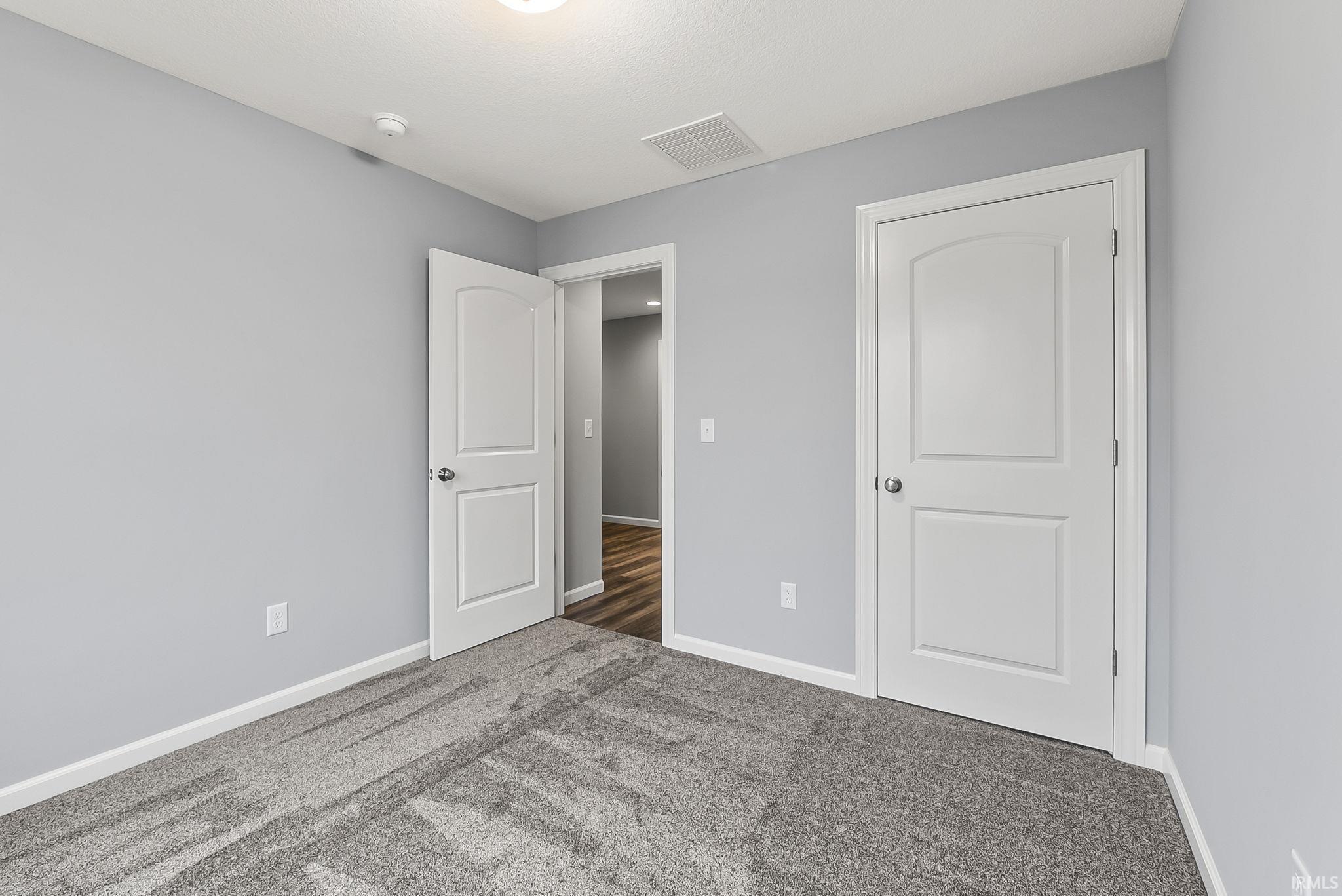 Light grey walls complementing grey patterned carpeting