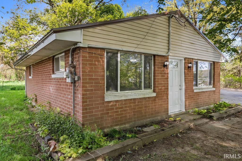 Brick exterior with a white entry door featuring a glass inset