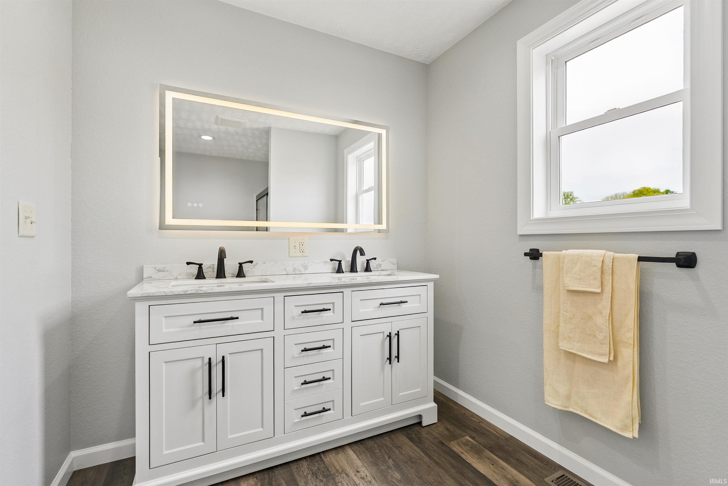 Double vanity with white cabinetry and dark hardware, featuring dual sinks and matte black faucets