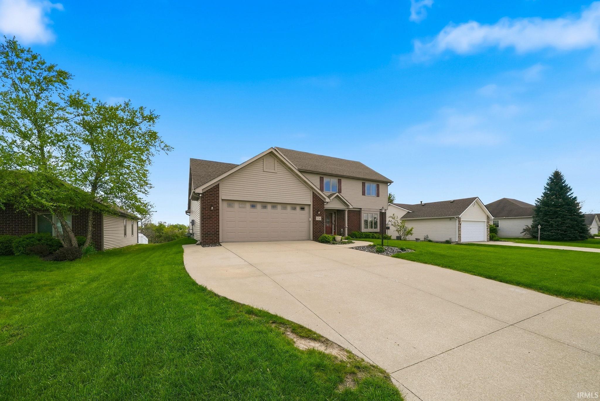Two-story residence featuring a two-car garage, concrete driveway, and a gabled roofline