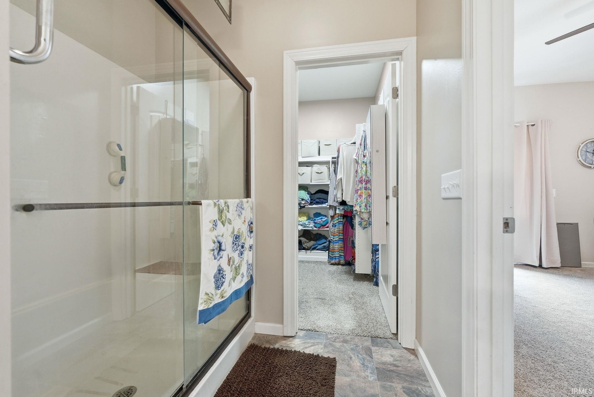 Walk-in shower with sliding glass door and grab bar