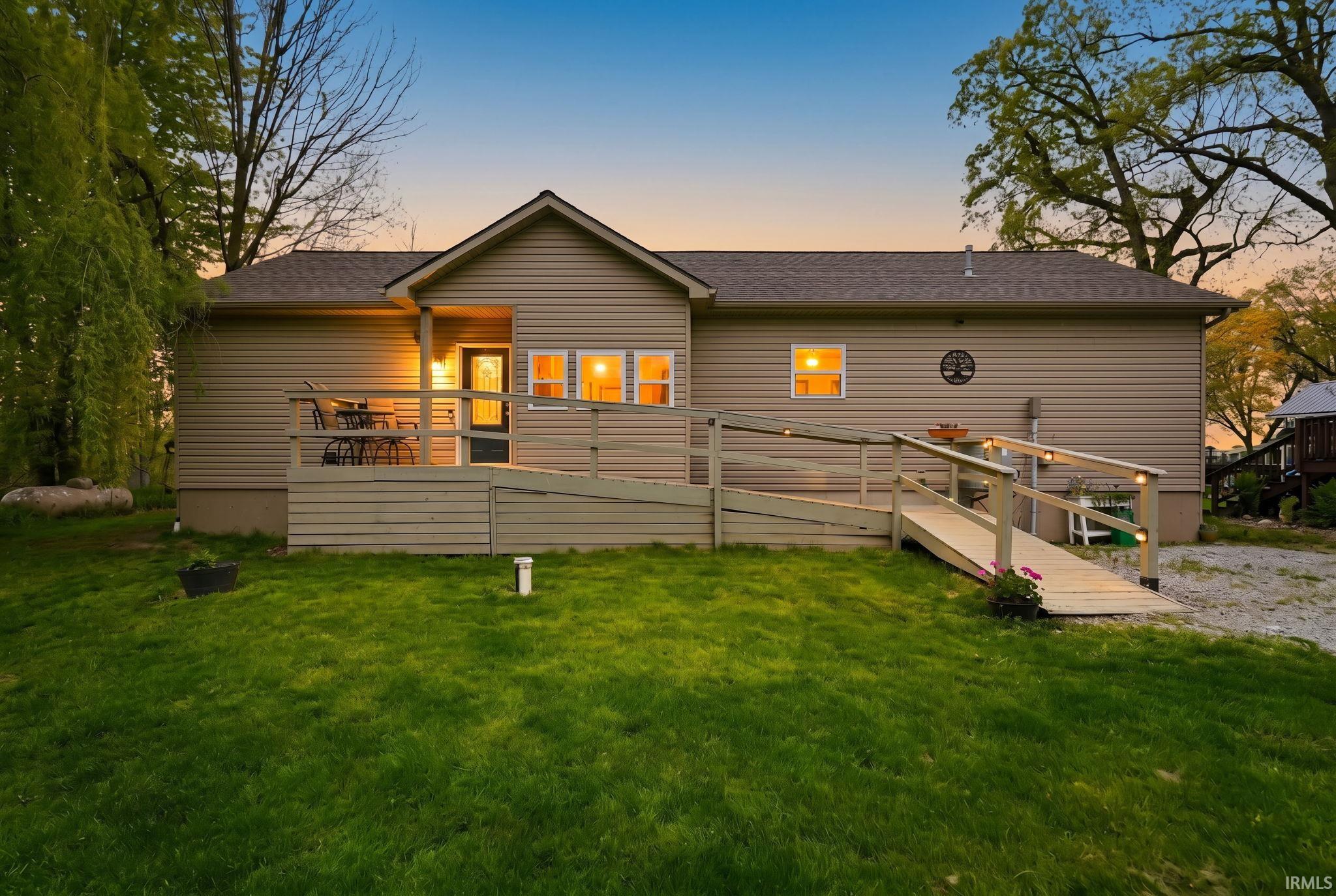 Exterior with horizontal siding, a covered entry, and a wooden deck
