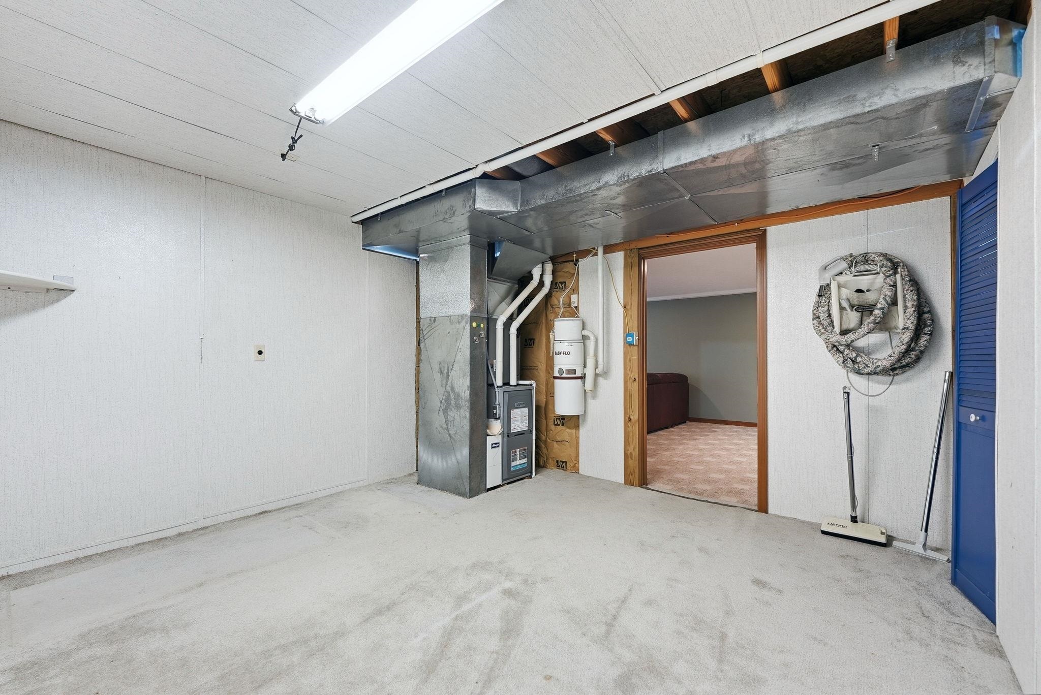 Utility room featuring a furnace, water heater, and exposed ductwork