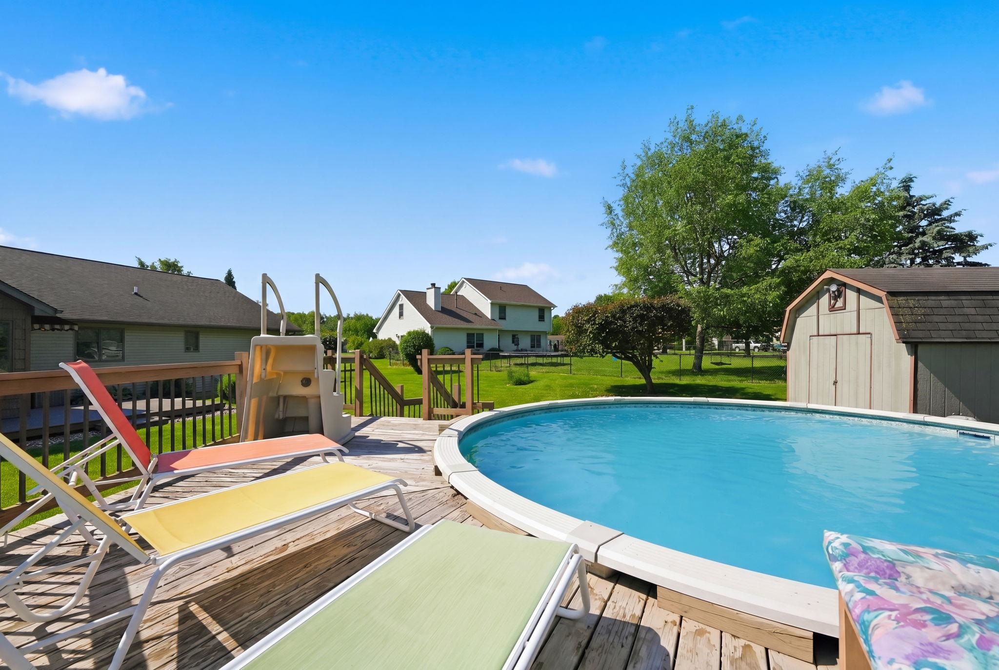 Expansive wood deck featuring an above-ground pool with surrounding wood decking